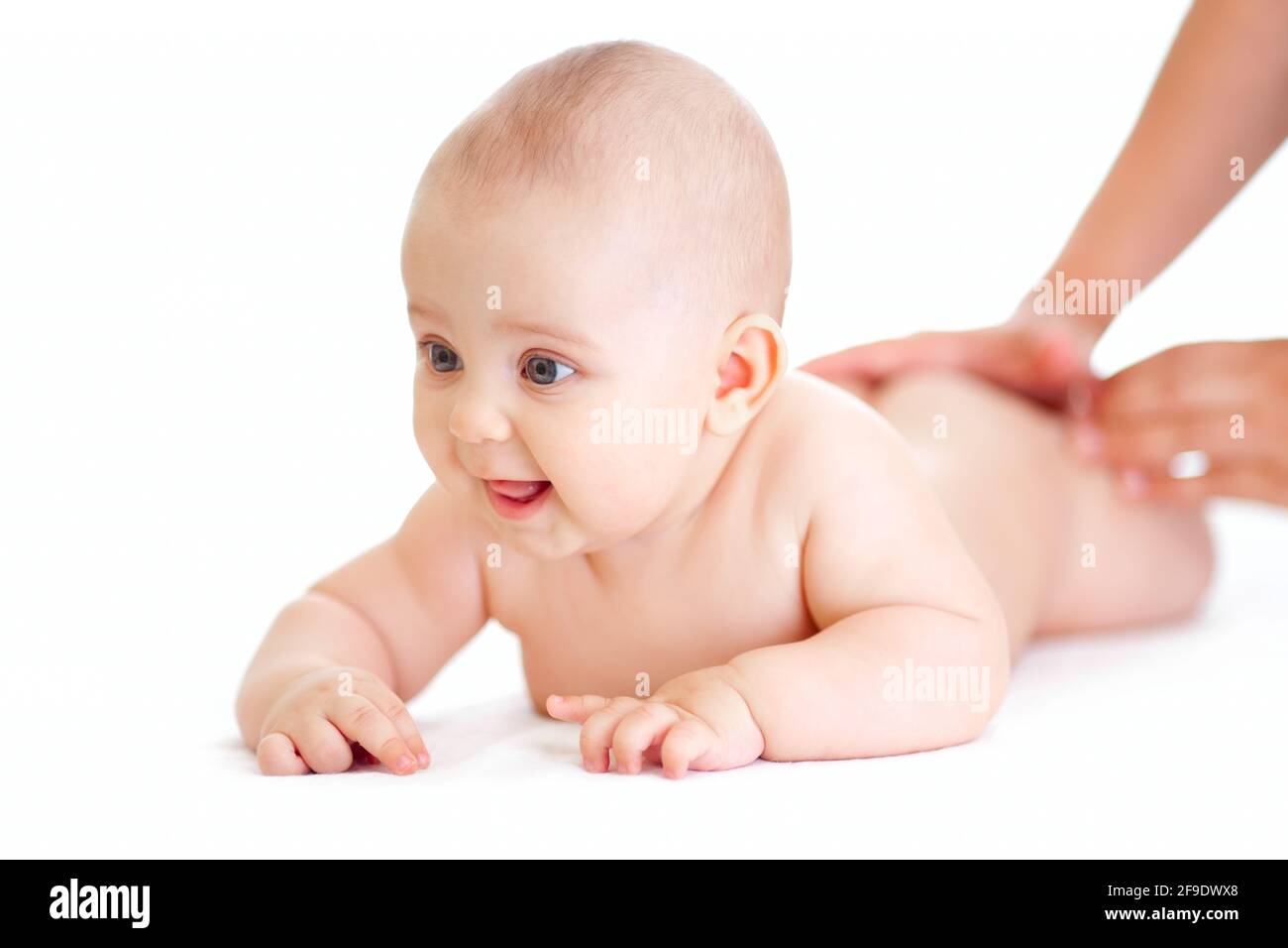 Glücklich Baby Junge liegen isoliert bekommen Massage Stockfoto