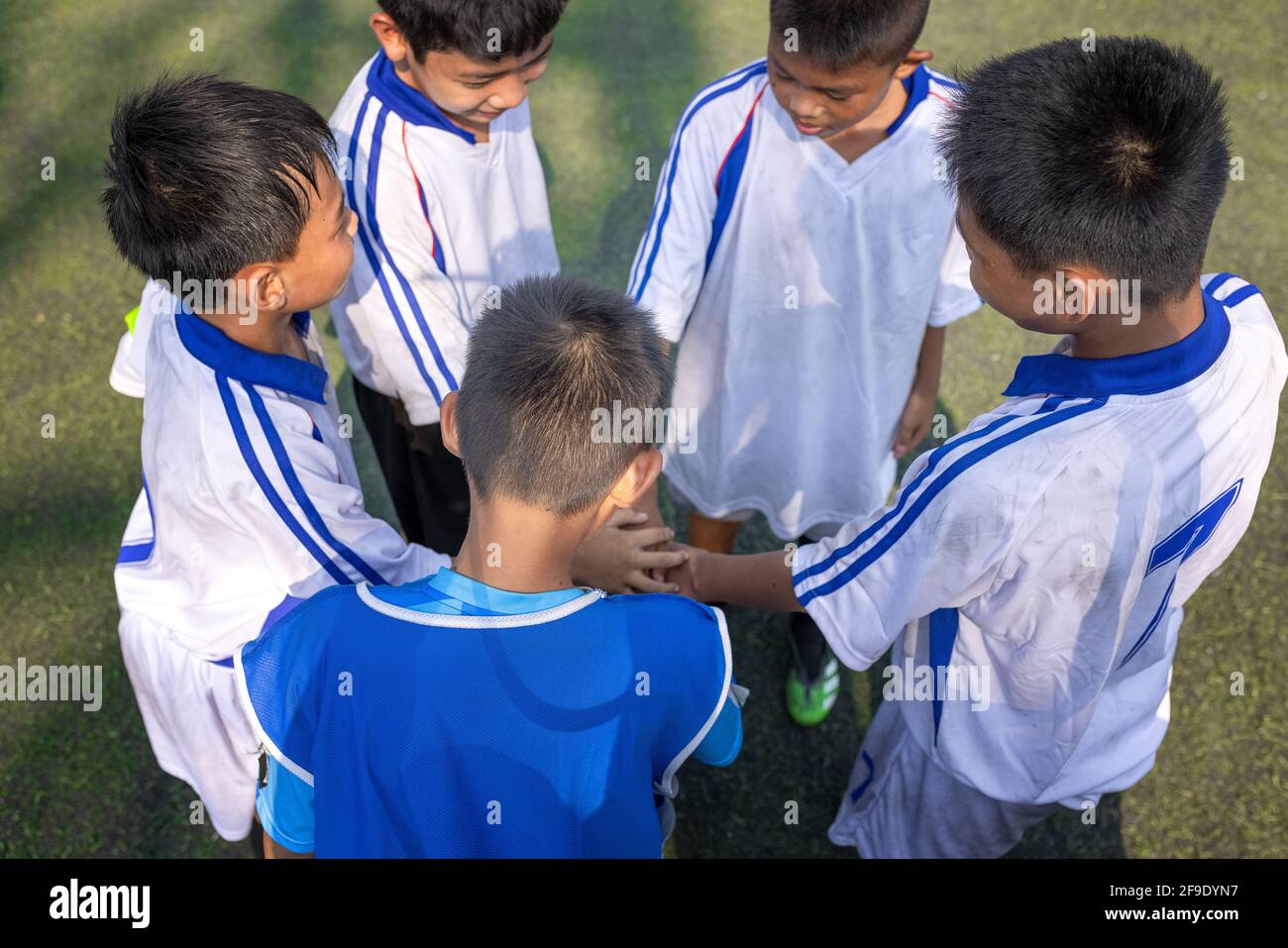 Blick von unten auf junge Fußballspieler, die Hände mitbringen Gemeinsam vor dem Spiel Stockfoto