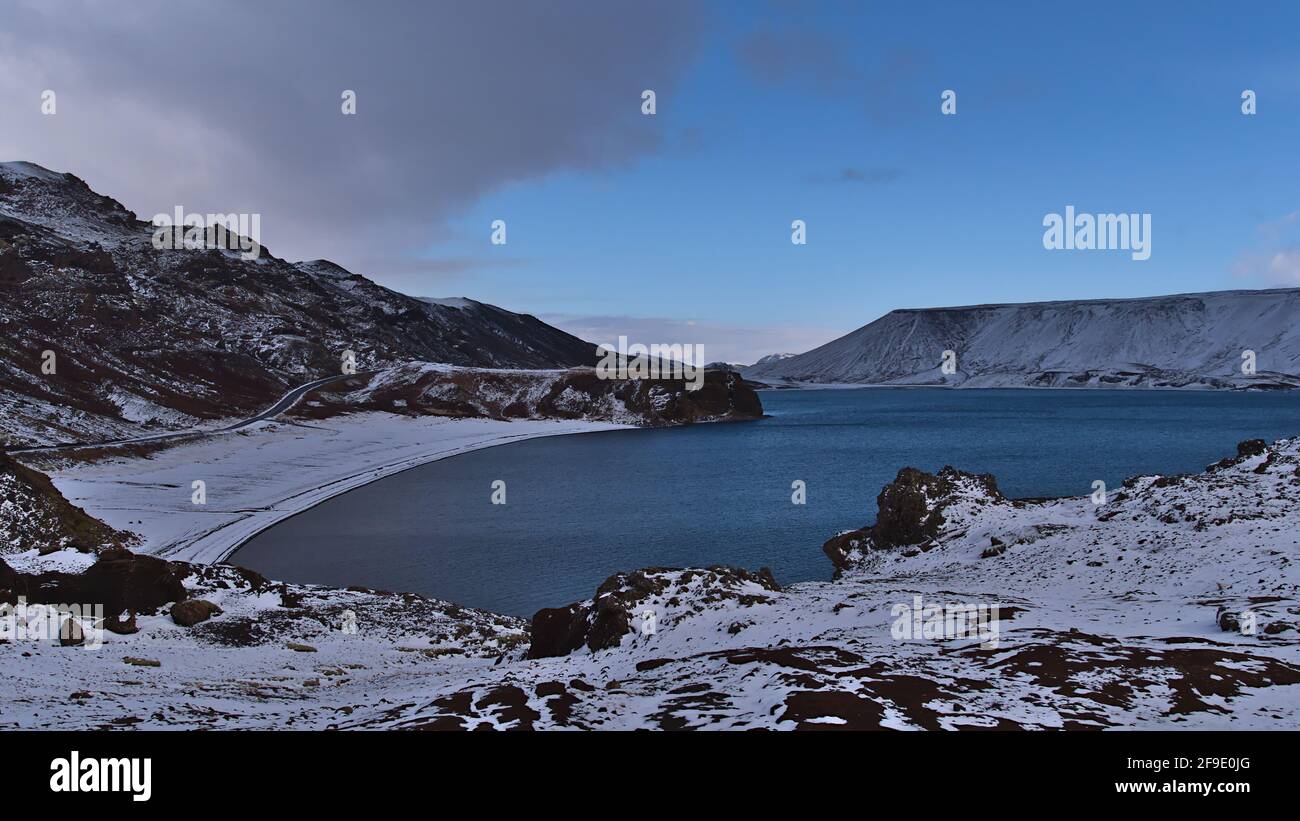 Schöne Aussicht auf den nördlichen Teil des Kleifarvatn-Sees in Krýsuvík, Halbinsel Reykjanes, Island mit felsigem Strand, Landstraße und Bergen. Stockfoto