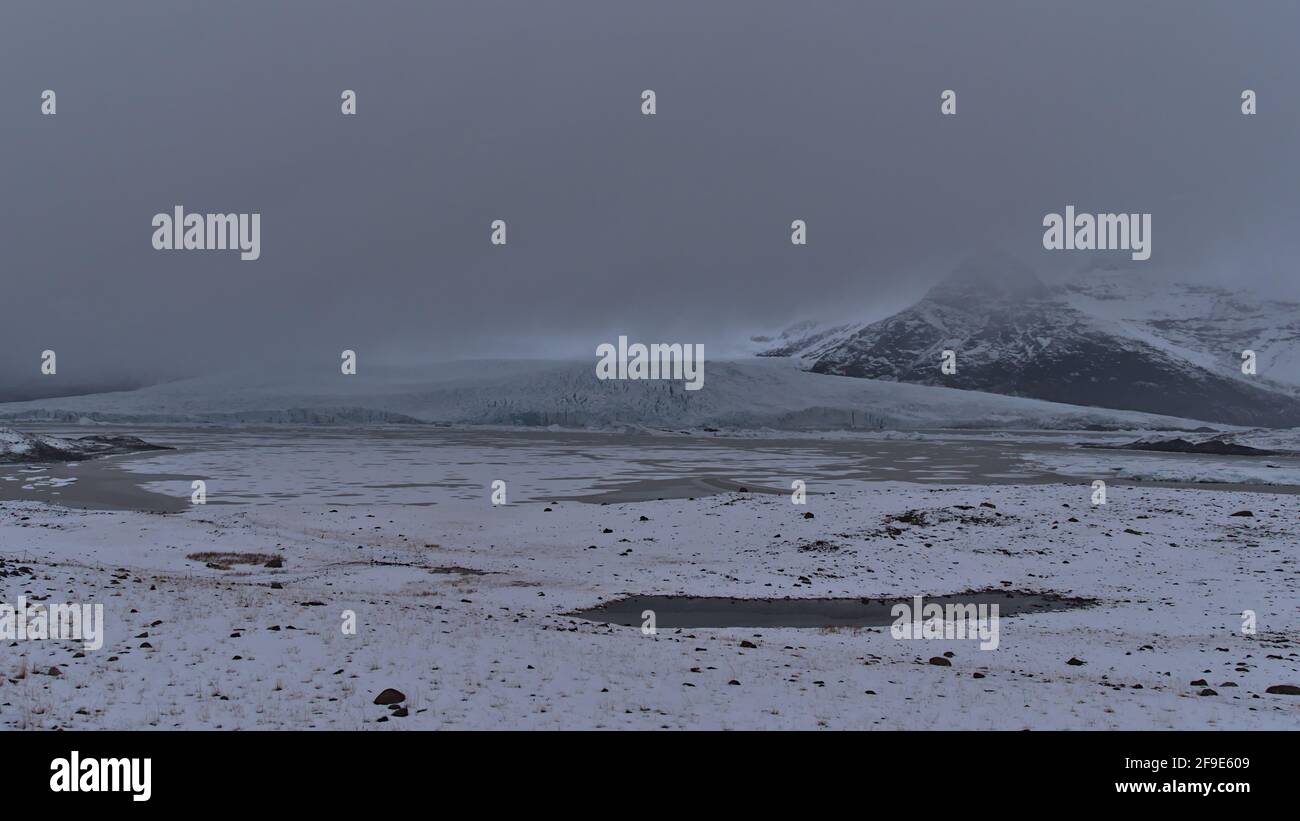 Mystischer Blick auf die Gletscherlagune Fjallsárlón im Süden Islands mit Fjallsjökull, einem Auslaufgletscher des Vatnajökull, und zerklüfteten Bergen. Stockfoto