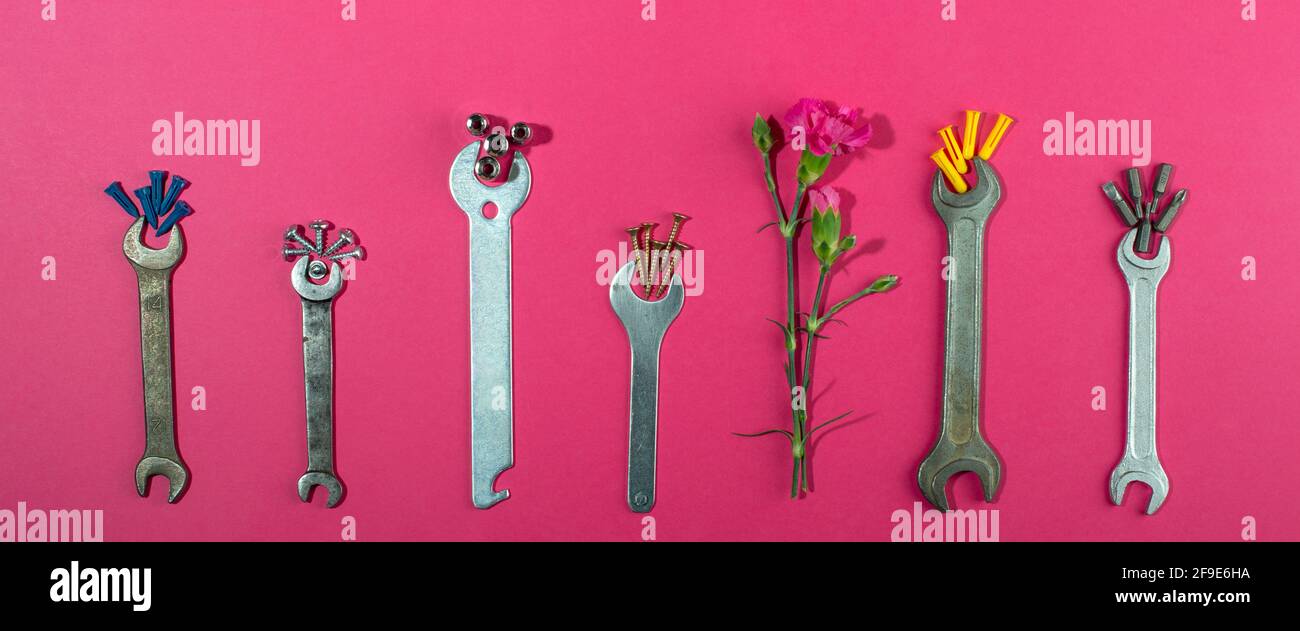 Labor Day Hintergrundkonzept, 1. Mai Konzept. Schlüssel und Nelke rosa Nelke Blume auf rosa Hintergrund. Flach liegend, Draufsicht. Banner. Stockfoto