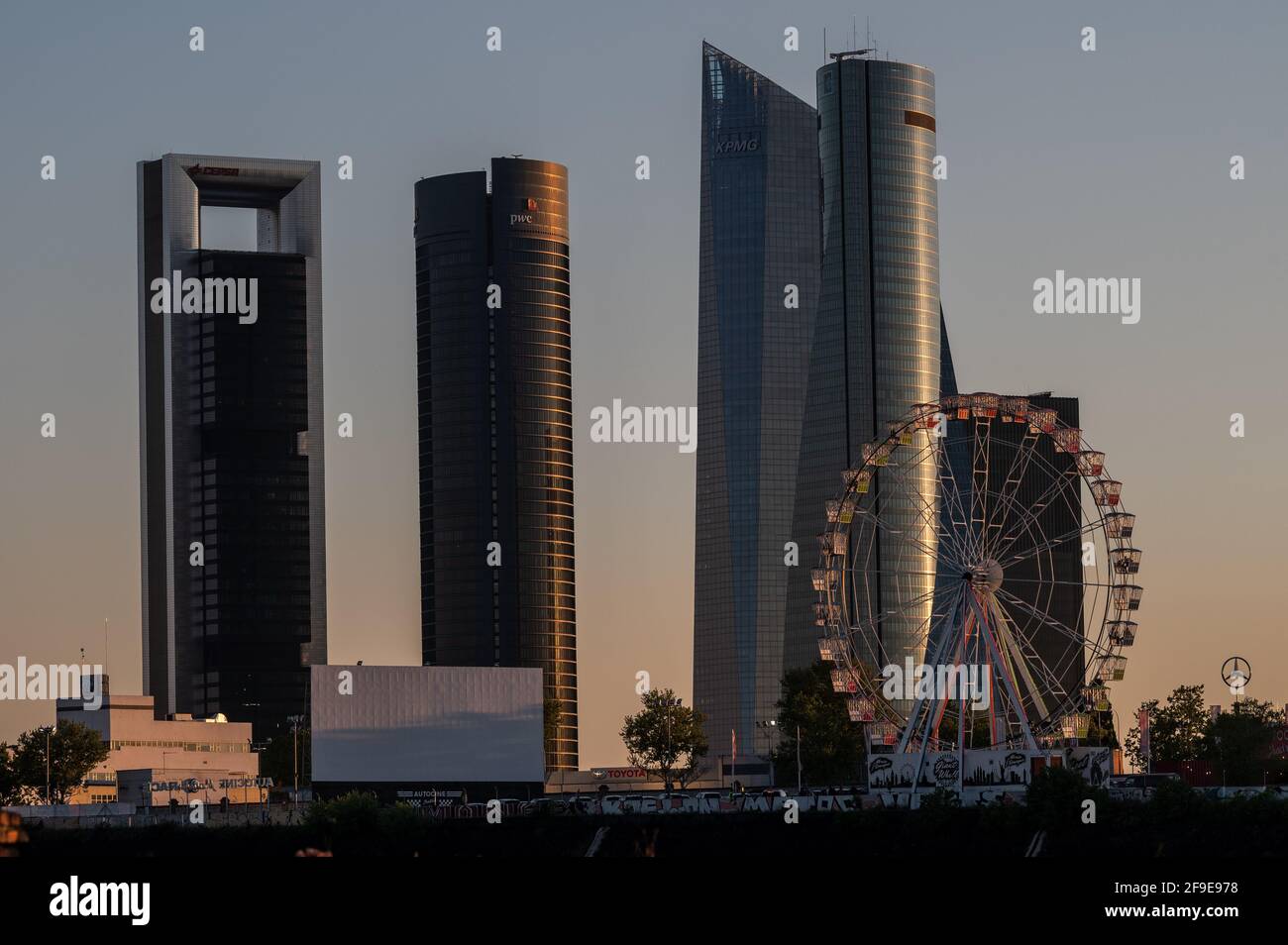 Madrid, Spanien. April 2021. Ein kürzlich installiertes Riesenrad dreht sich vor einer Filmvorführung im Drive-in-Kino (Autocines Race Madrid) mit Blick auf die Skyline mit den Wolkenkratzern des Four Towers Business Area. Quelle: Marcos del Mazo/Alamy Live News Stockfoto