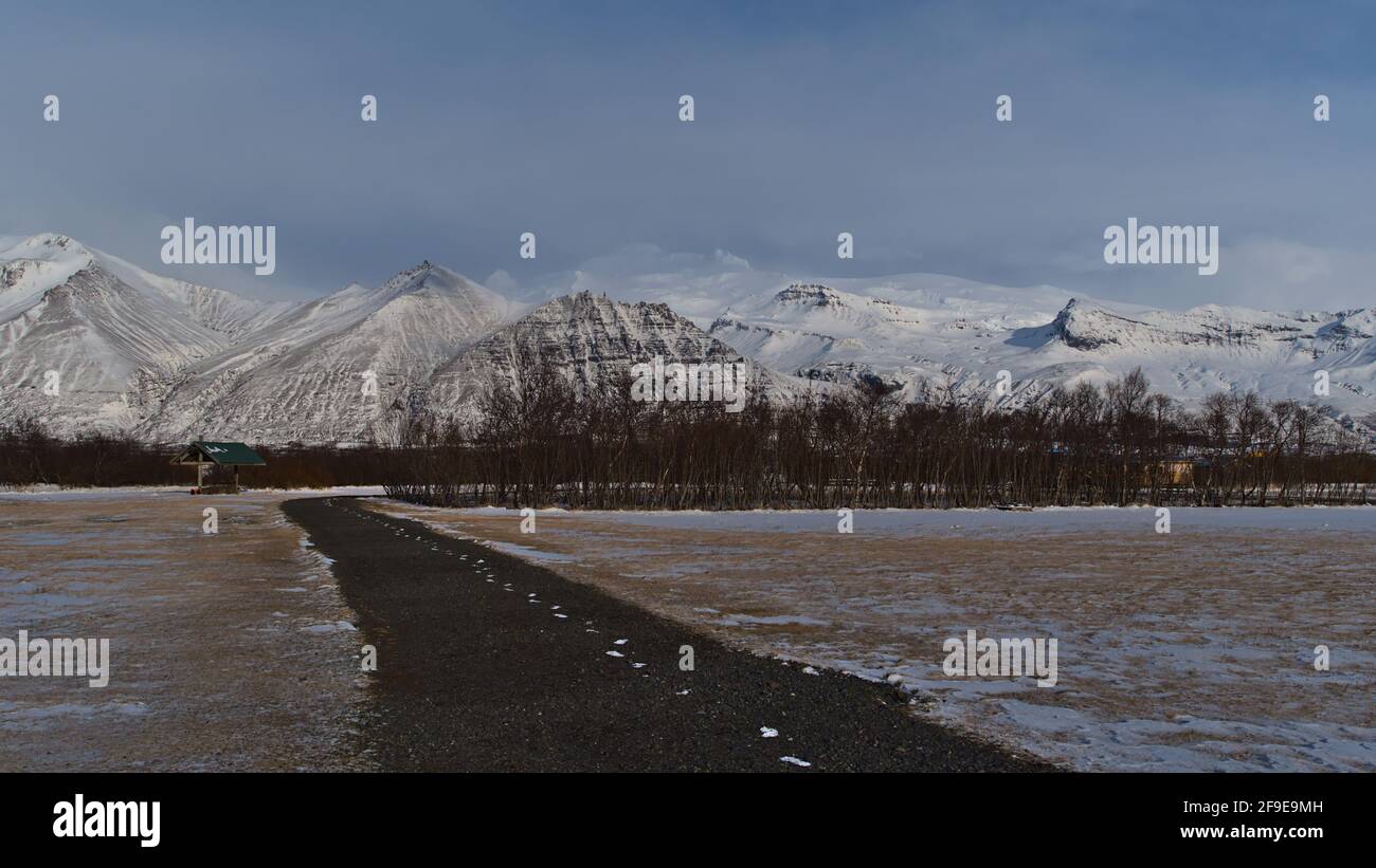 Leerer Campingplatz im Skaftafell Nationalpark, im Süden Islands in der Wintersaison mit den majestätischen eisbedeckten Bergen des Vulkans Öræfajökull. Stockfoto