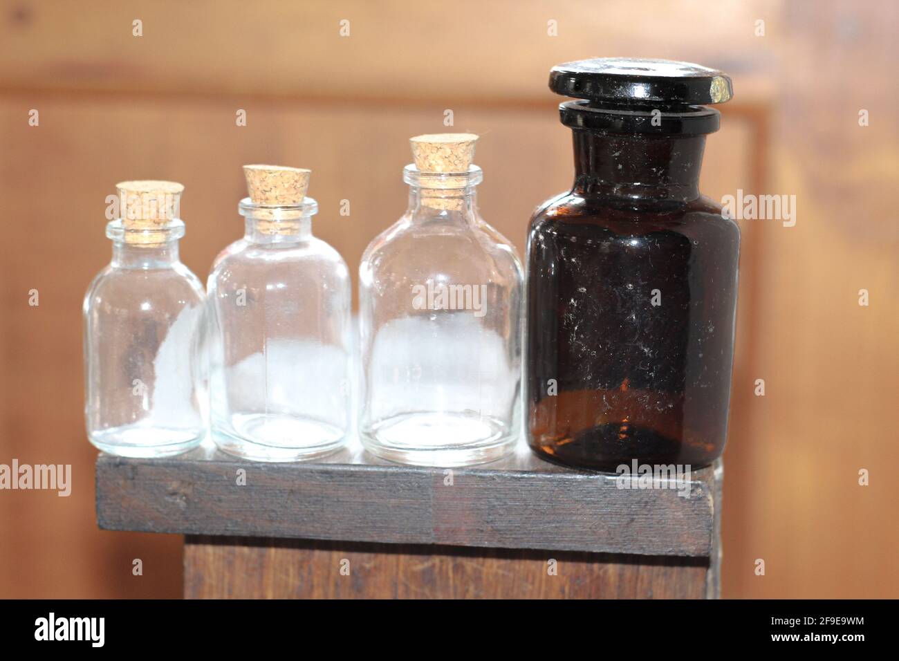 Eine Nahaufnahme der vier Glasflaschen mit Korken Der Holztisch Stockfoto