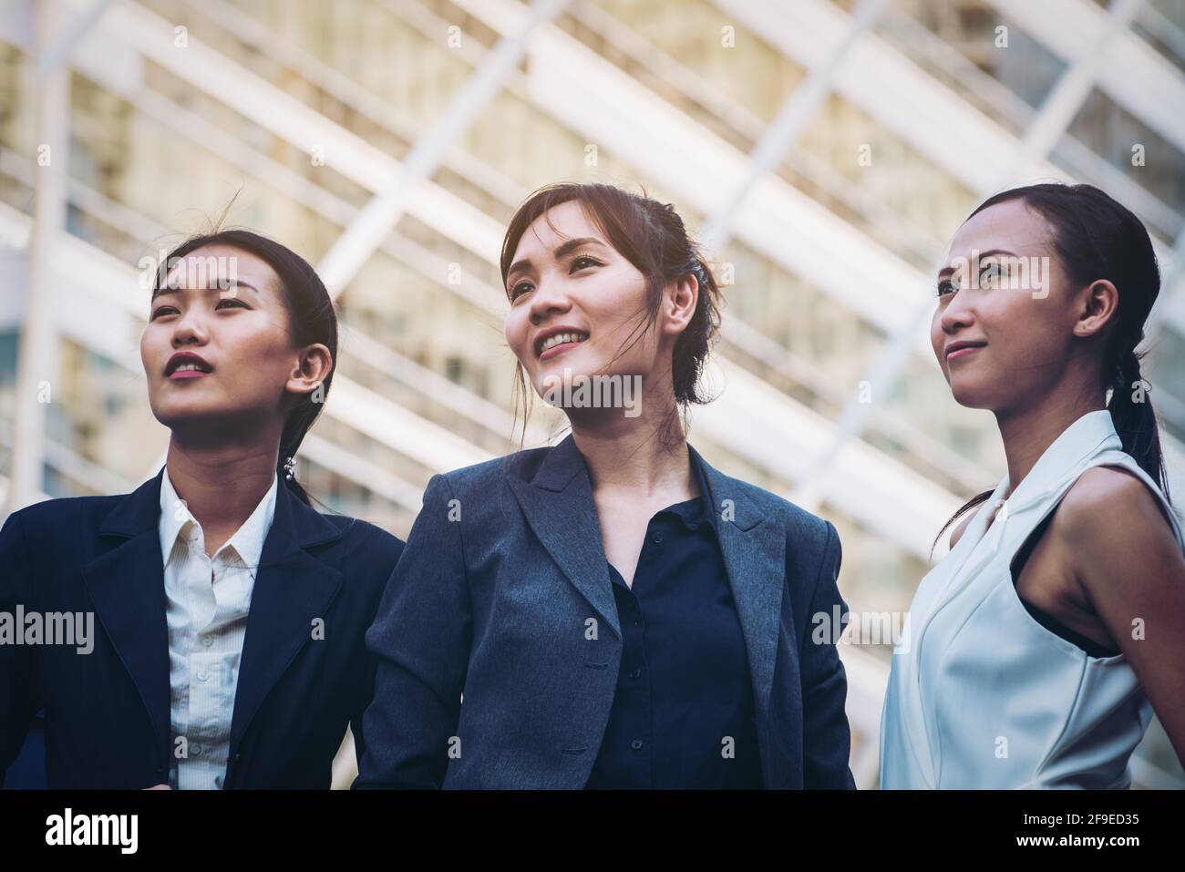 Selbstbewusste Geschäftsfrauen stehen vor dem Hintergrund der Stadt in Reihe. Konzept des Frauen-Business-Teams, Frauenführung. Stockfoto