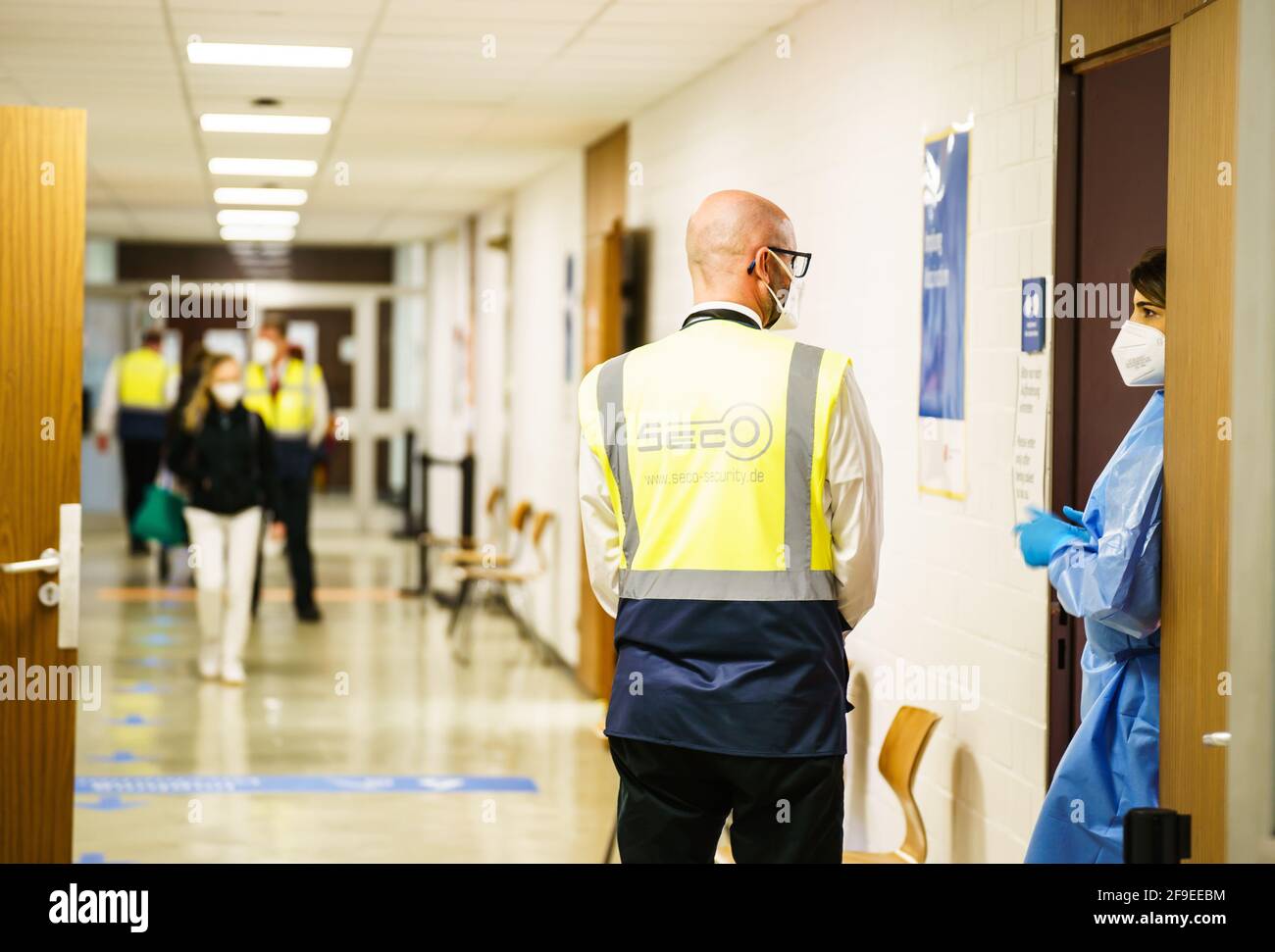 Mainz, Deutschland. April 2021. Ein Mitarbeiter spricht mit medizinischen Fachkräften im Impfzentrum in der Landeshauptstadt. Nach Angaben des Impfkoordinators werden rund 40,000 Impfdosen (je 20,000 AstraZeneca und BioNTech) in den Impfzentren in Rheinland-Pfalz verabreicht. Möglich wird dies durch eine spezielle Impfkampagne am Wochenende. Quelle: Andreas Arnold/dpa/Alamy Live News Stockfoto