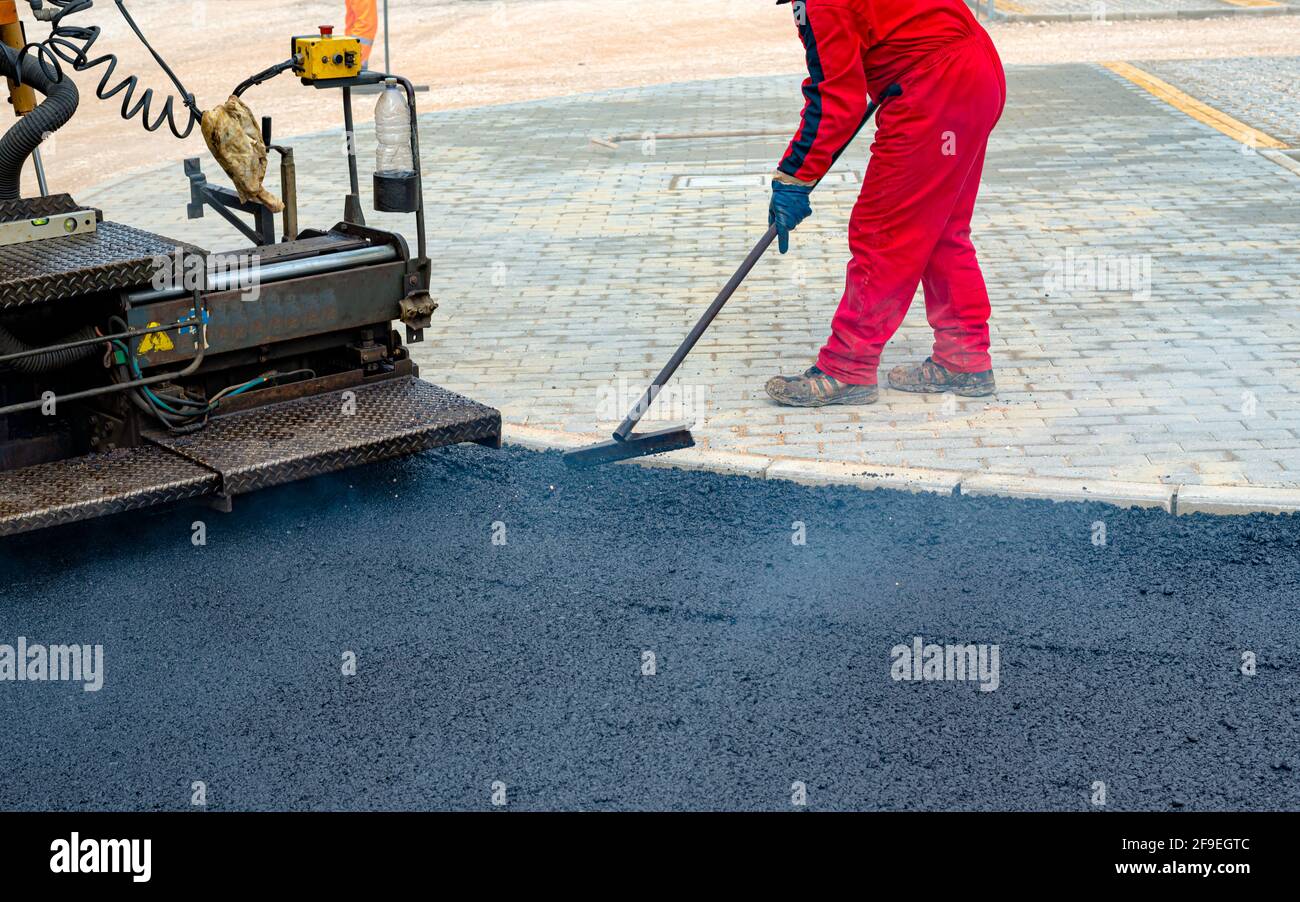 Arbeiter-Movemen regelt den Verkehr von Fahrzeugen in einer Kreuzung Betroffen von Bauarbeiten an der Glasfaserleitung Stockfoto