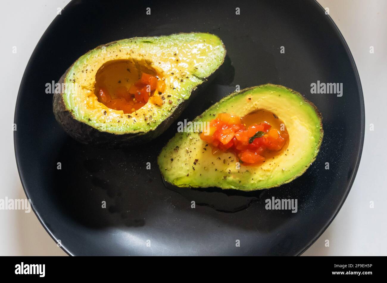 Avocado mit Salz, Pfeffer, Olivenöl und Salsa Stockfoto