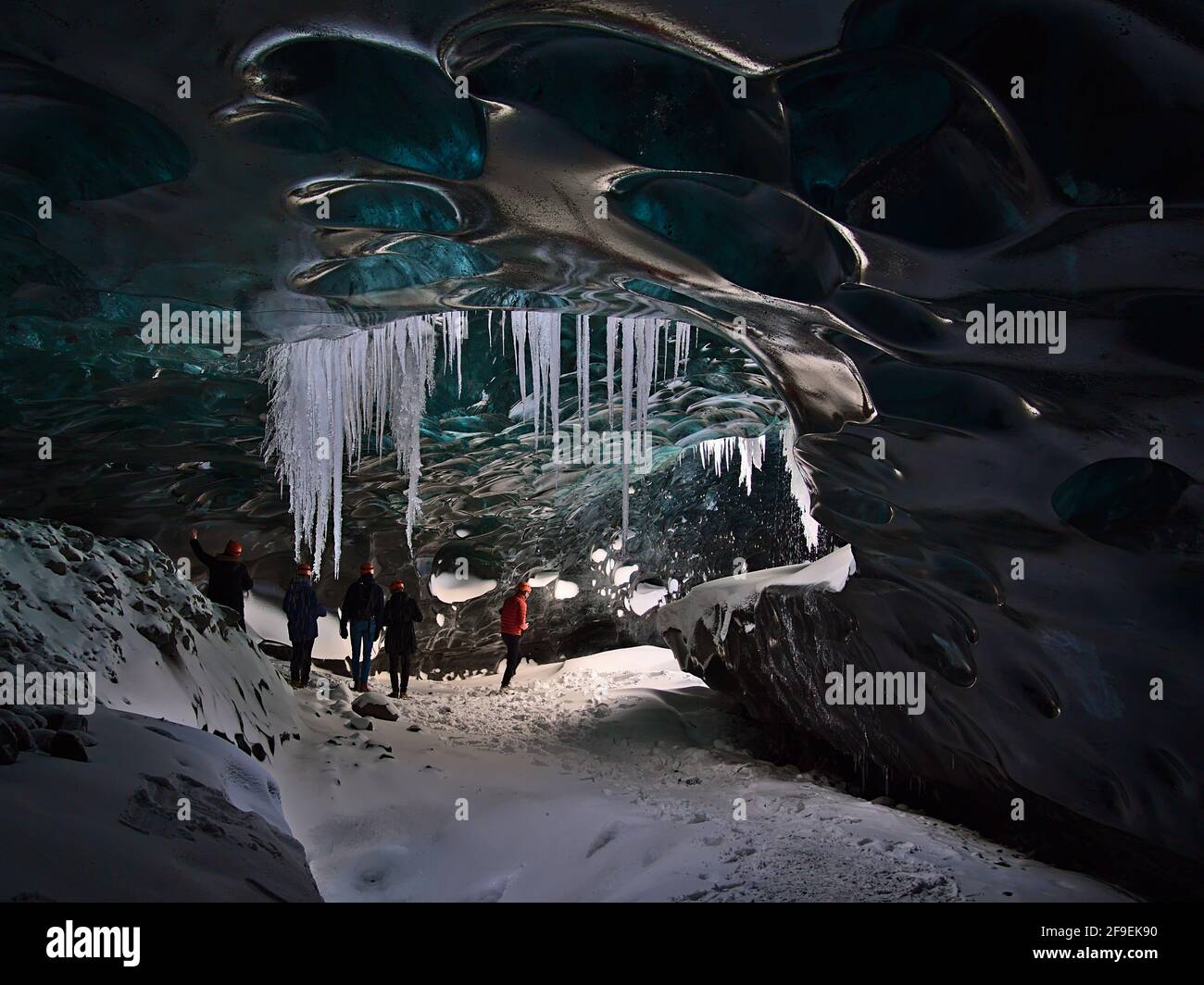 Eine Gruppe von Touristen, die die Sapphire Ice Cave, die sich im Gletscher Breiðamerkurjökull, Vatnajökull, Island, befindet, auf einer Tour mit einem moulin-Loch erkunden. Stockfoto