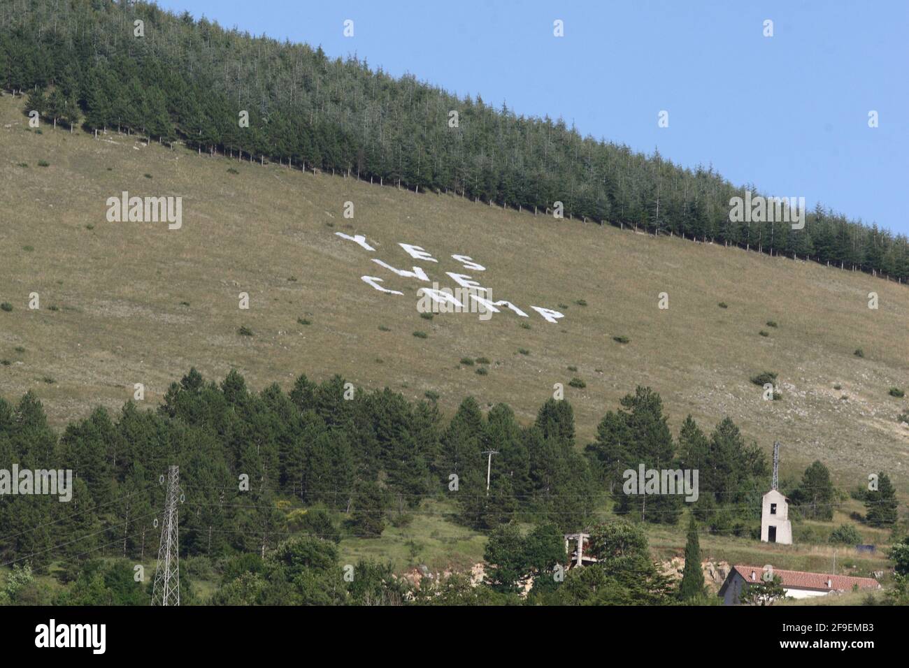 L'Aquila, Italien - 9. Juli 2009: 'Ja, wir zelten!' Die große Protestinschrift mit Plastikbuchstaben einiger Stadtkomitees der Erdbebengebiete auf dem Hügel von Roio Stockfoto