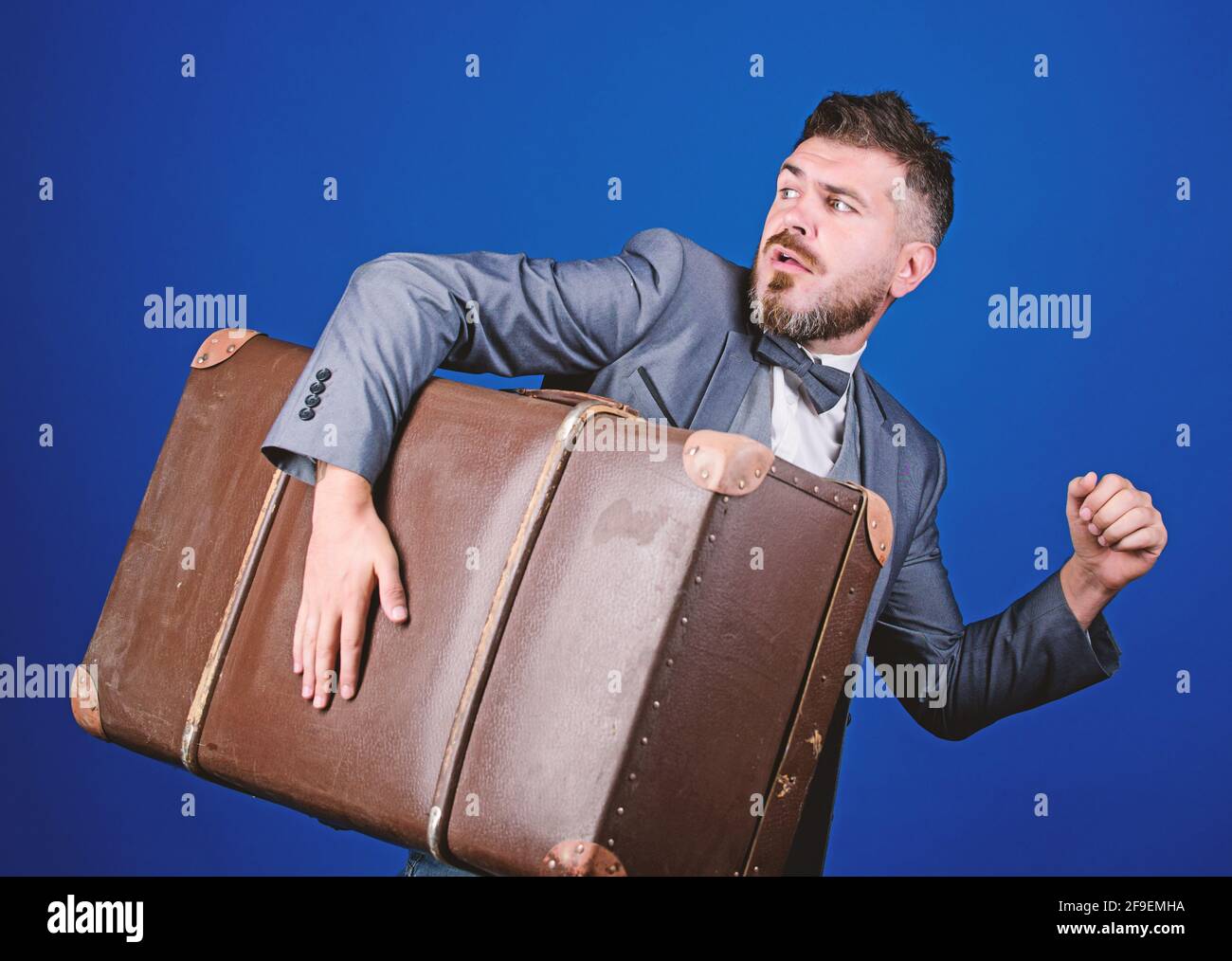 Dieb rauf mit schwerem Koffer. Jahrhundertdiebstahl. Lieferservice. Reise- und Gepäckkonzept. Hippster Reisender mit Gepäck. Gepäckversicherung Stockfoto