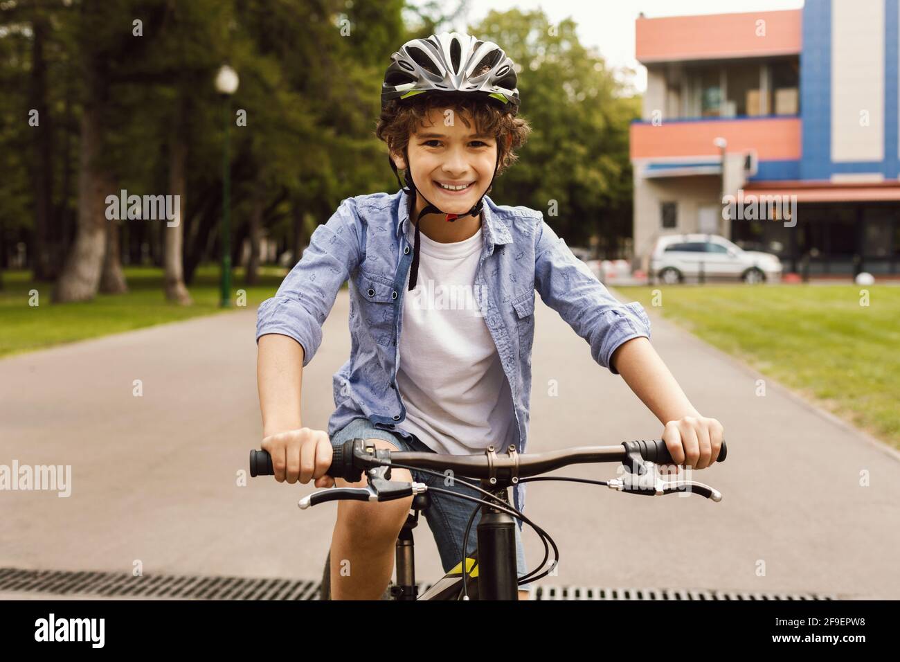 Lächelnder Junge, der im Park Fahrrad fahren lernt Stockfoto