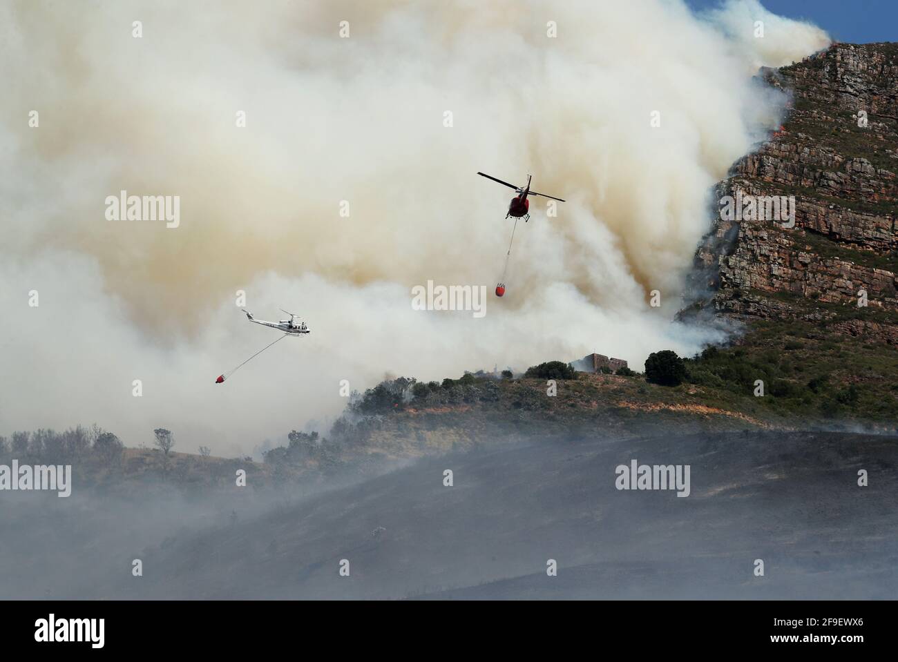 Hubschrauber kämpfen um die Eindämmung eines Buschfeuers, das am Hang des Tafelbergs in Kapstadt, Südafrika, ausbrach, 18. April 2021. REUTERS/Mike Hutchings Stockfoto