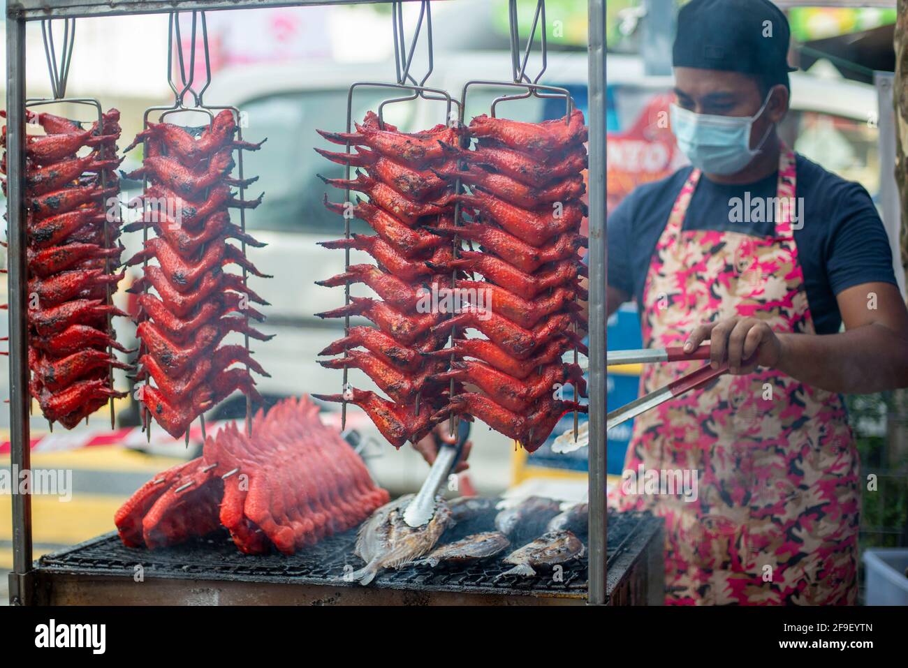 Kuala Lumpur, Malaysia. April 2021. Ein Verkäufer, der eine Gesichtsmaske trägt, bereitet in Kuala Lumpur, Malaysia, am 18. April 2021 Essen zu. Malaysia meldete 2,195 neue COVID-19-Infektionen, teilte das Gesundheitsministerium am Sonntag mit, was die landesweite Gesamtzahl auf 375,054 beläuft. Quelle: Chong Voon Chung/Xinhua/Alamy Live News Stockfoto