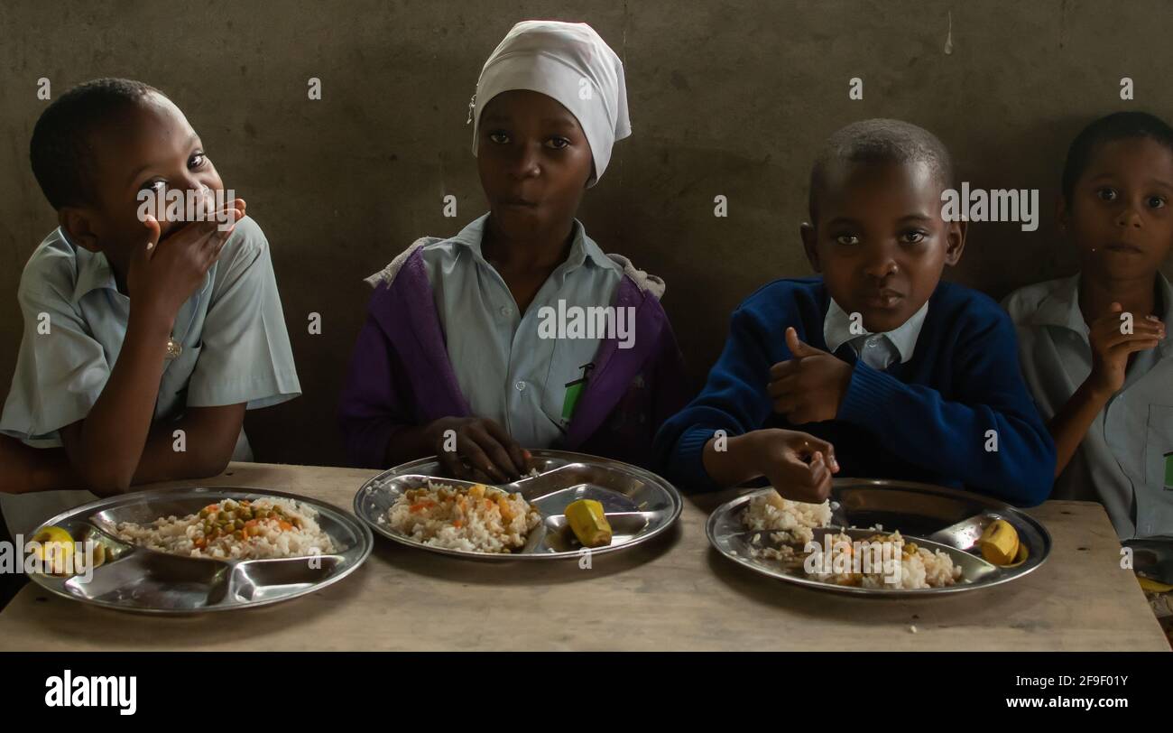 Dodoma, Tansania. 08-18-2019. Muslimische schwarze Schüler genießen das Mittagessen, nachdem sie in einer ländlichen Gegend Tansanias in der Schule waren. Stockfoto