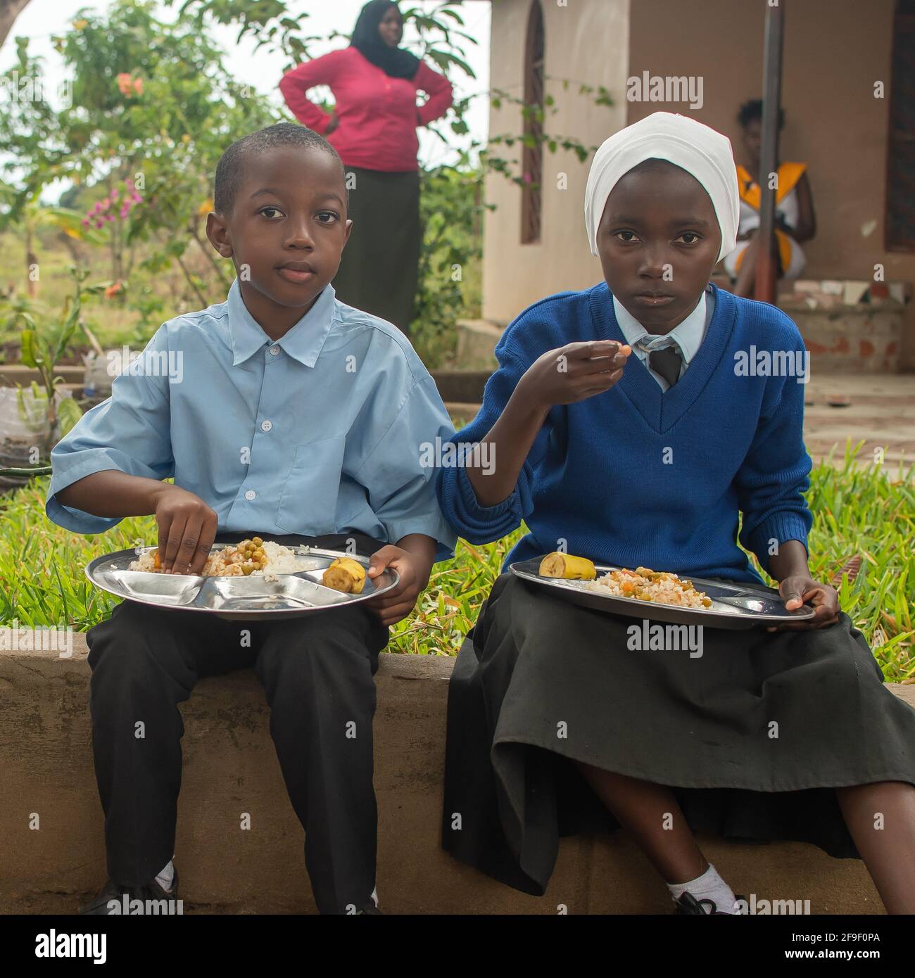 Dodoma, Tansania. 08-18-2019. Zwei muslimische schwarze Studenten essen nach den Klassenaktivitäten in Tansania in einer ländlichen Schule zu Mittag. Stockfoto