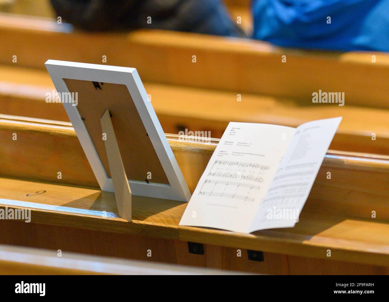 Dresden, Deutschland. April 2021. Ein Bilderrahmen und das Programm liegen auf einer Birne in der Frauenkirche während eines Gottesdienstes für die Pandemieopfer in der Corona-Krise. Zahlreiche Kirchen und Kapellen öffnen ihre Türen, um den Menschen die Möglichkeit zu geben, an die Verstorbenen zu erinnern und für die Leidenden zu intervenieren, unter dem Motto "Zeit zum Klagen - Raum der Hoffnung". Es finden Gottesdienste, offene Kirchen, Andachten sowie Zeiten der Stille statt. Quelle: Robert Michael/dpa-Zentralbild/dpa/Alamy Live News Stockfoto