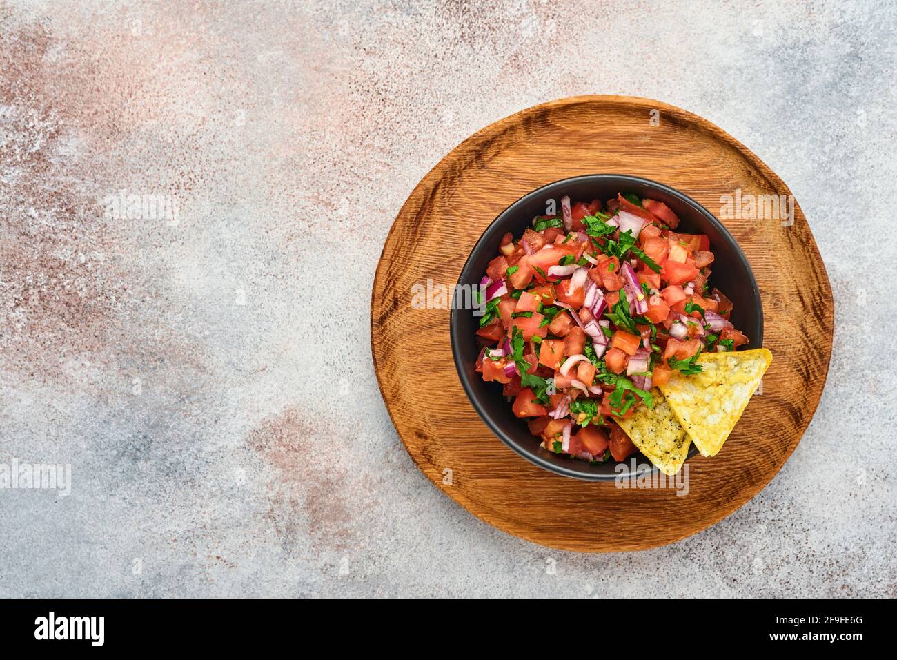 Traditionelle mexikanische Tomatensauce Salsa mit Nachos und Zutaten Tomaten, chile, Knoblauch, Zwiebel auf hellem Schieferstein Hintergrund. Konzept des lateinischen am Stockfoto