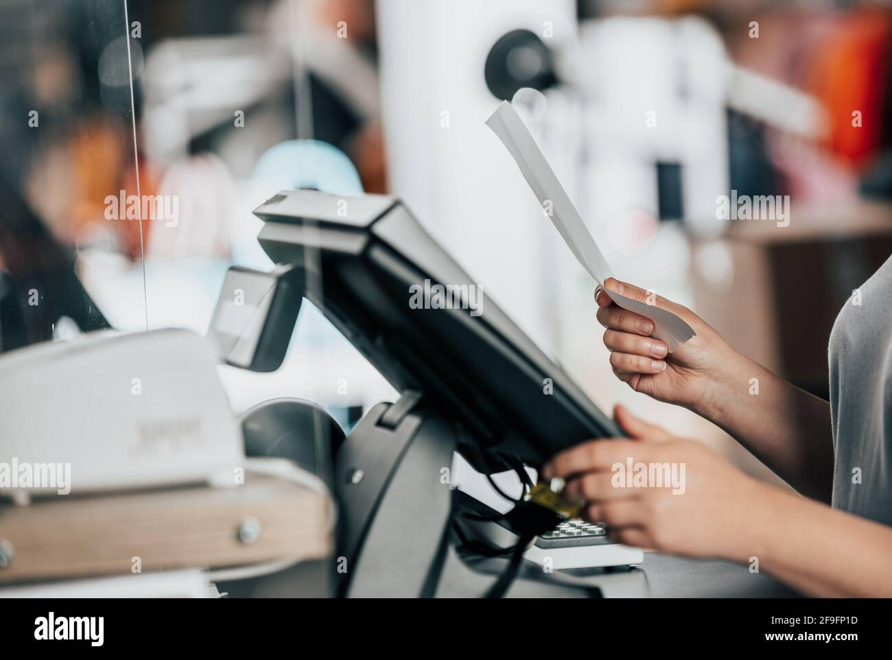 Junge Frau, die die Zahlung mit der Rechnung oder Rechnung an der Kasse im Shop abwickele, Finanzierungskonzept Stockfoto