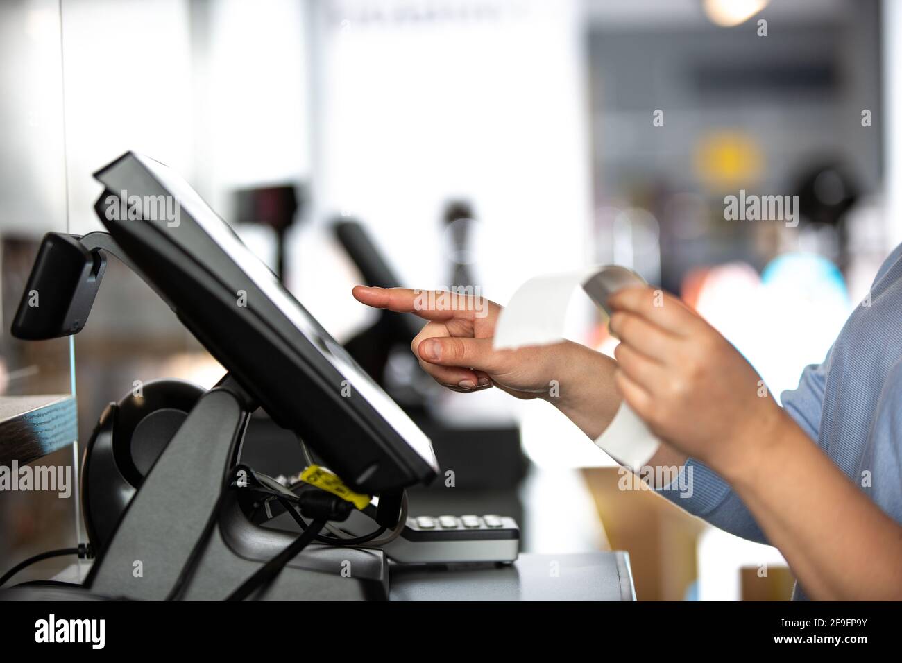 Junge Frau, die die Zahlung mit der Rechnung oder Rechnung an der Kasse im Shop abwickele, Finanzierungskonzept Stockfoto