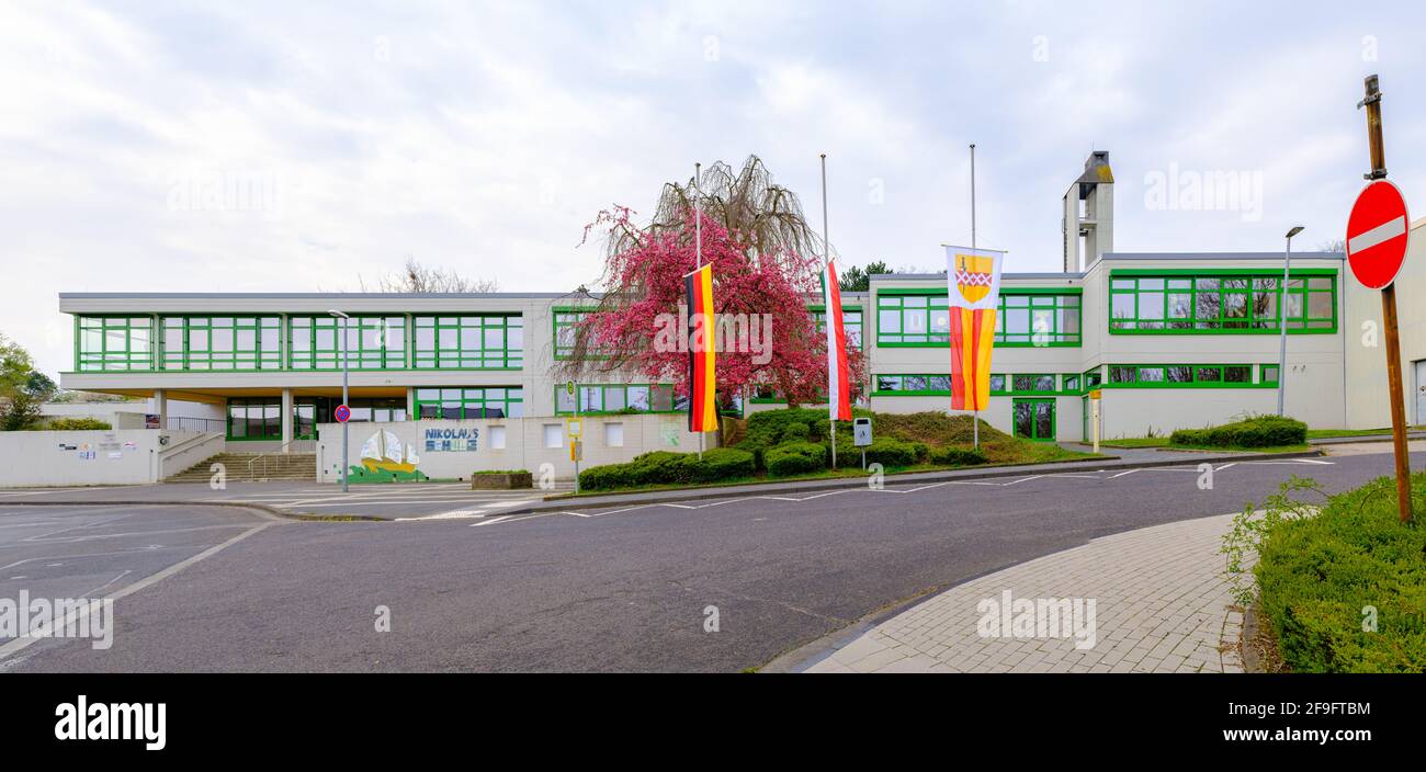 Bornheim, Nordrhein-Westfalen, Deutschland - 18. April 2021: Flaggen auf Halbmast an einer Grundschule in Trauer um die an COVID-19 Verstorbenen Stockfoto
