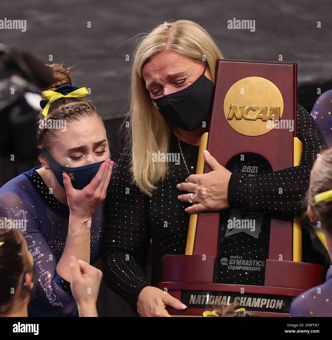 Fort Worth, TX, USA. April 2021. Bev Plocki, Cheftrainerin der Michigan-Frauen (neben Natalie Wojcik), hält nach dem Sieg der Wolverine bei der NCAA Women's National Collegiate Turner Championship 2021 in der Dickies Arena in Fort Worth, TX, die NCAA-Meisterschaftspokal. Kyle Okita/CSM/Alamy Live News Stockfoto