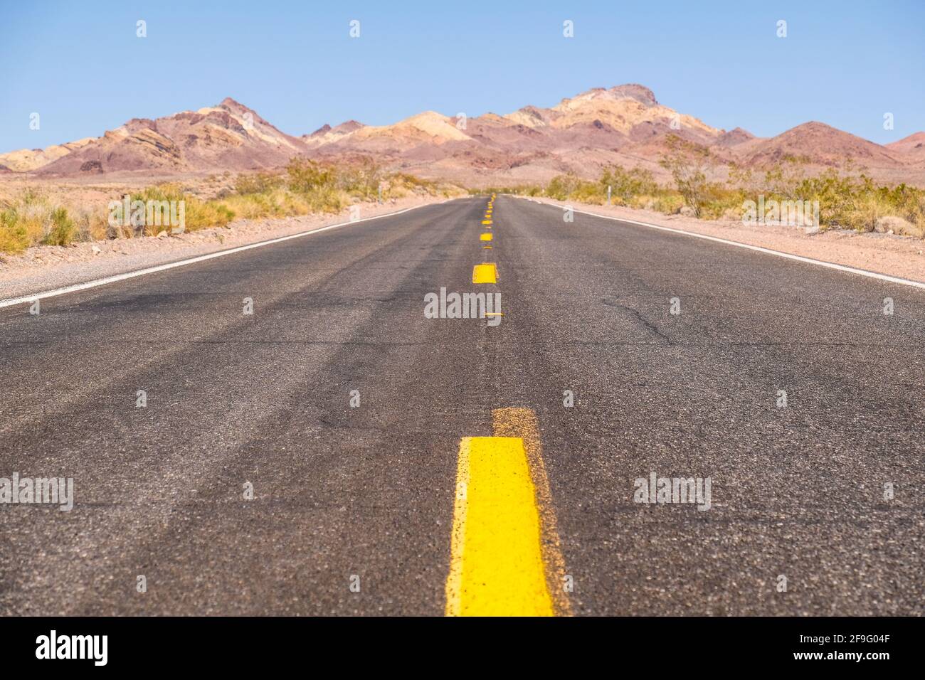 Die Gelbe Mittlere Verkehrslinie Auf Dem Blacktop Empty Highway Erstreckt Sich In Far Horizon im Death Valley National Park Stockfoto
