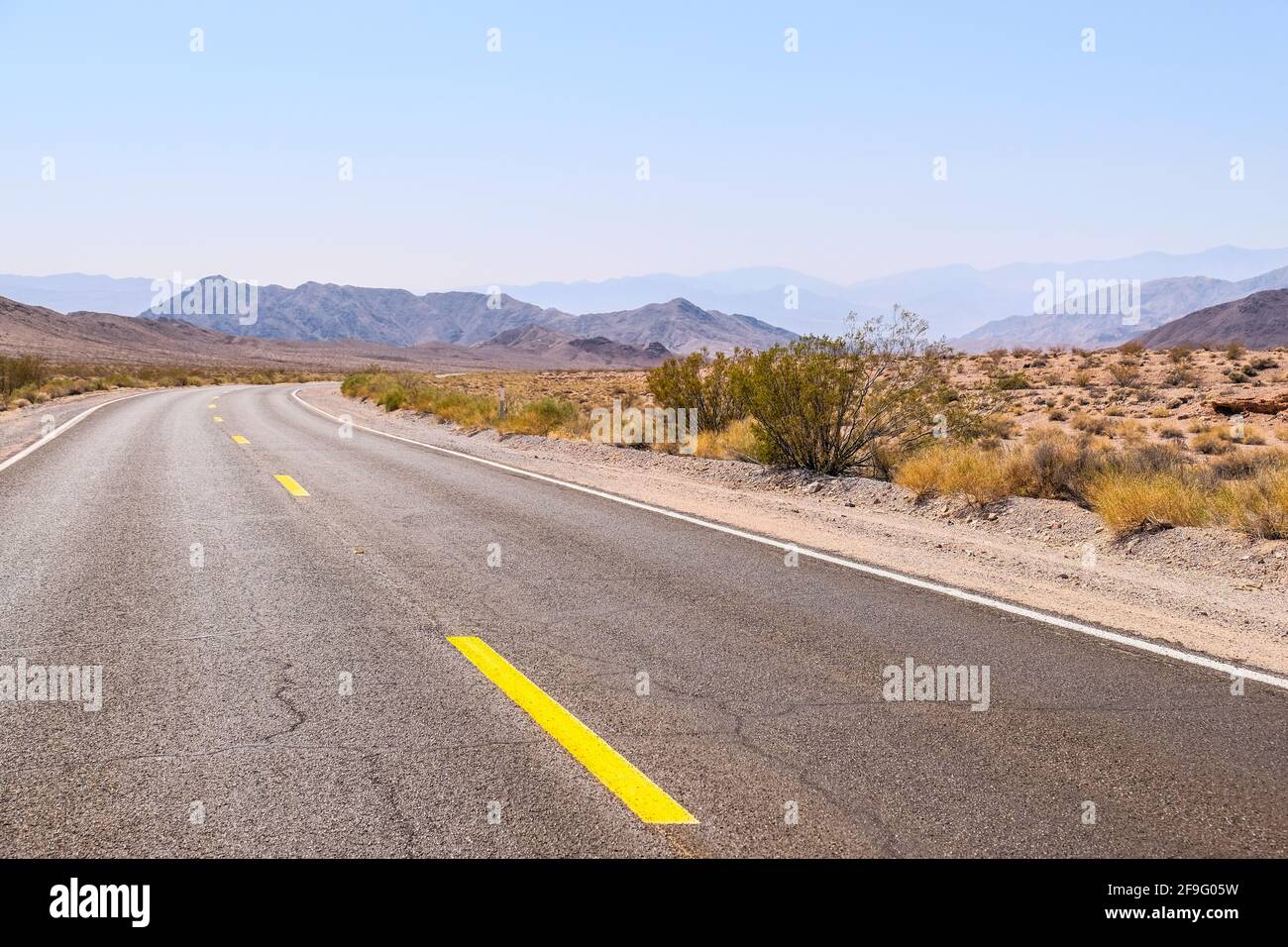 Die Gelbe Mittlere Verkehrslinie Auf Dem Blacktop Empty Highway Erstreckt Sich In Far Horizon im Death Valley National Park Stockfoto