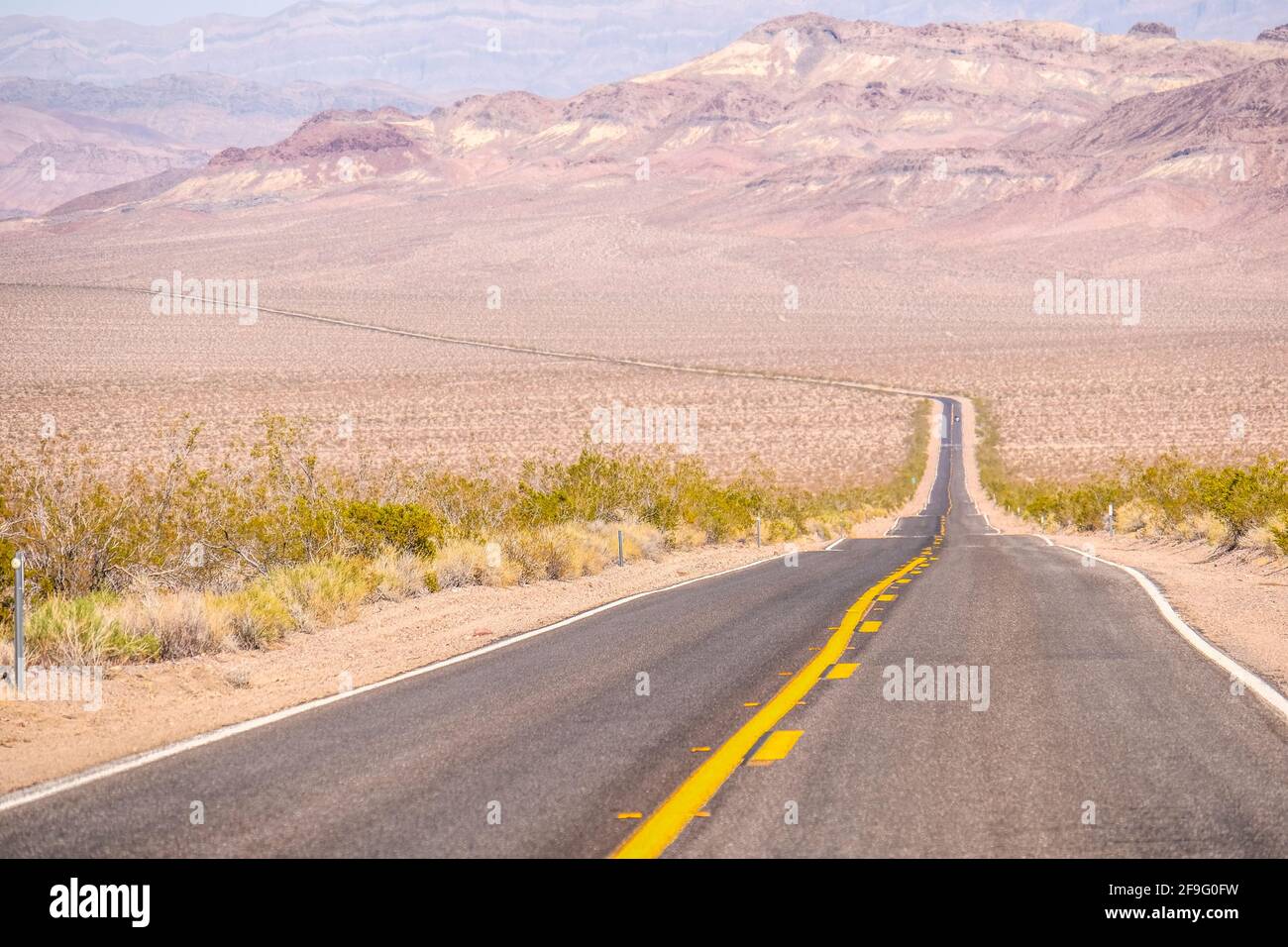 Die Gelbe Mittlere Verkehrslinie Auf Dem Blacktop Empty Highway Erstreckt Sich In Far Horizon im Death Valley National Park Stockfoto