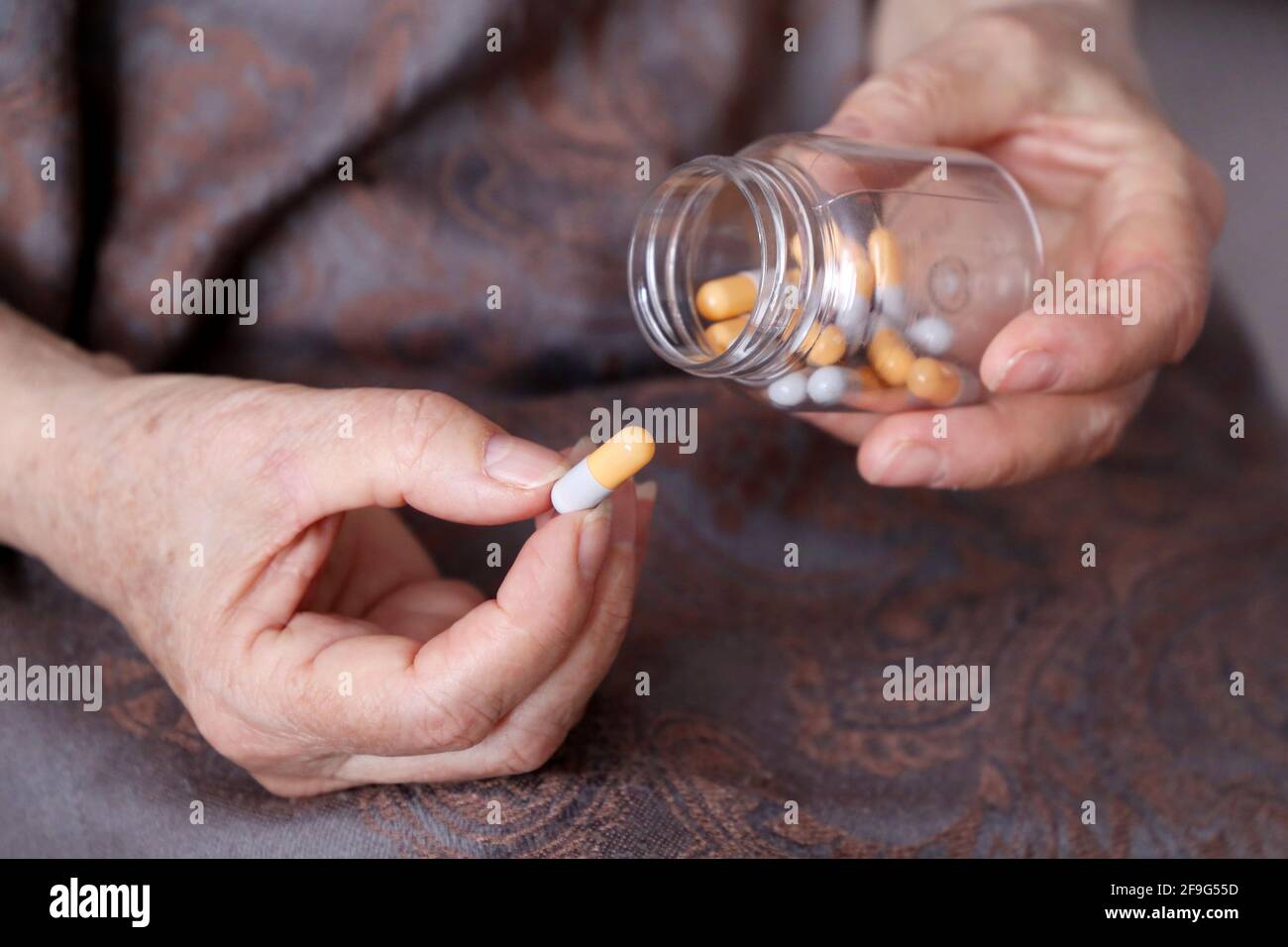 Ältere Frau mit Pillen in faltigen Händen. Medikamente in Kapseln, Einnahme von Beruhigungsmitteln, Antibiotika oder Vitaminen Stockfoto