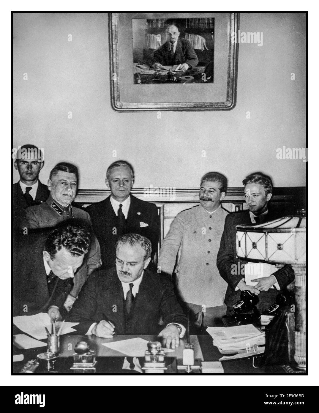 MOLOTOW 1939 der sowjetische Außenminister Wjatscheslaw Molotow unterzeichnet am 28. September 1939 in Moskau den deutsch-sowjetischen Freundschaftsvertrag; hinter ihm stehen Richard Schulze-Kossens (Ribbentrops Adjutant), Boris Schaposchnikow (Generalstabschef der Roten Armee), Joachim von Ribbentrop, Joseph Stalin, Wladimir Pavlov (sowjetischer Übersetzer). Alexei Schkvarzew (sowjetischer Botschafter in Berlin) steht neben Molotow. Portrait von Lenin hinter Moskau Sowjetunion Russland Stockfoto