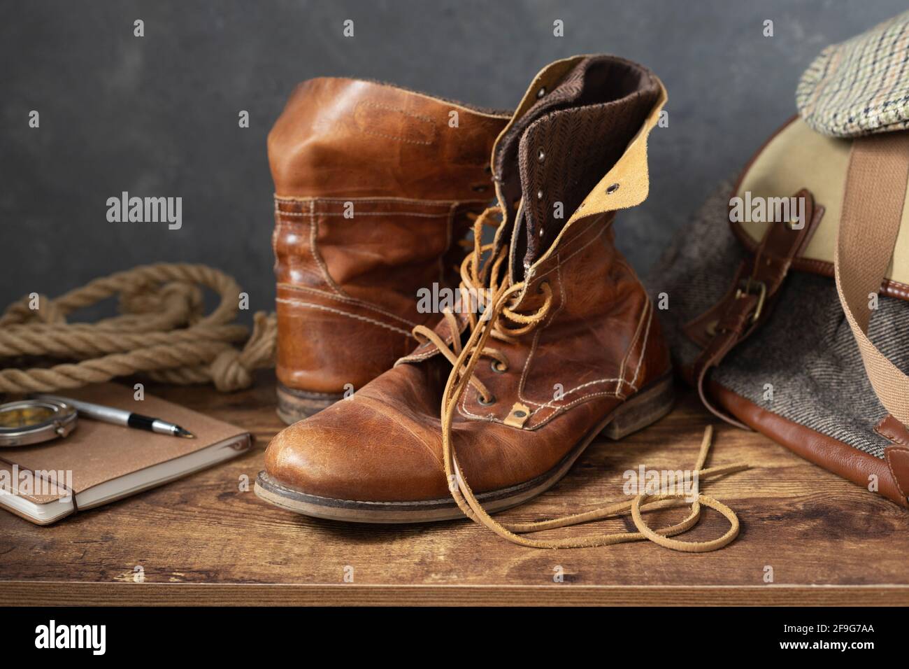 Alte Leder Reise Vintage Stiefel Schuhe und Tasche an Holztisch, mit Wand  Hintergrundstruktur Stockfotografie - Alamy