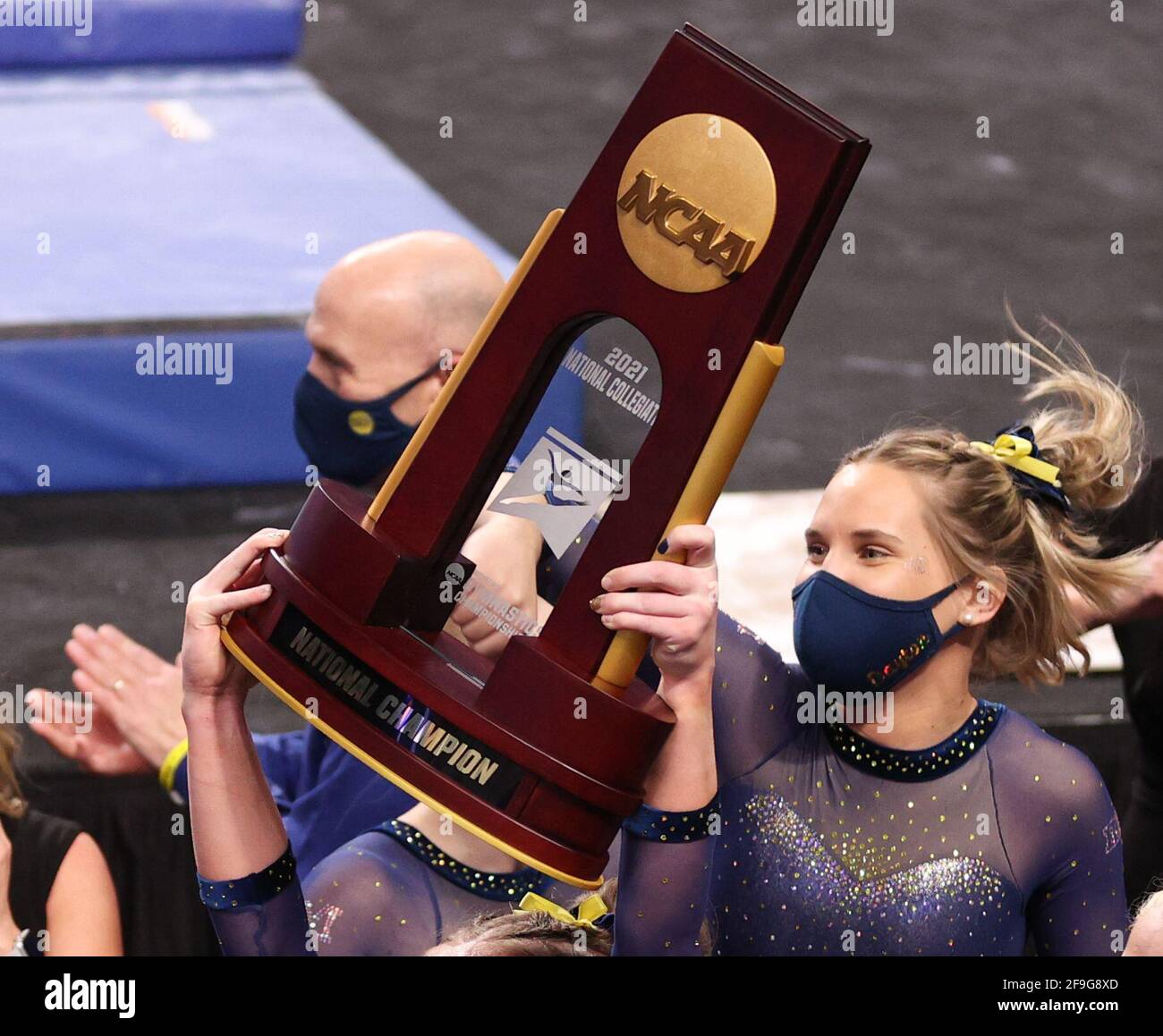 Fort Worth, TX, USA. April 2021. Nach dem Sieg der Wolverine bei den Finals der NCAA Women's National Collegiate Gymnastics Championship 2021 in der Dickies Arena in Fort Worth, TX, hält eine Turner aus Michigan die NCAA-Meisterschaftspokal. Kyle Okita/CSM/Alamy Live News Stockfoto
