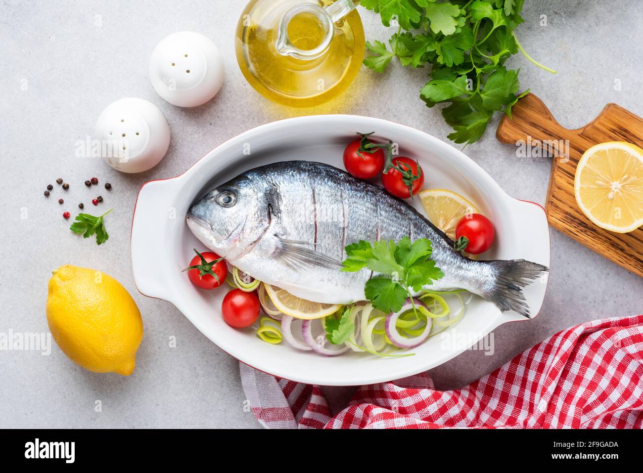 Dorado mit Gemüse bereit zum Backen in Keramikschale. Draufsicht. Kochen gesundes Abendessen Stockfoto