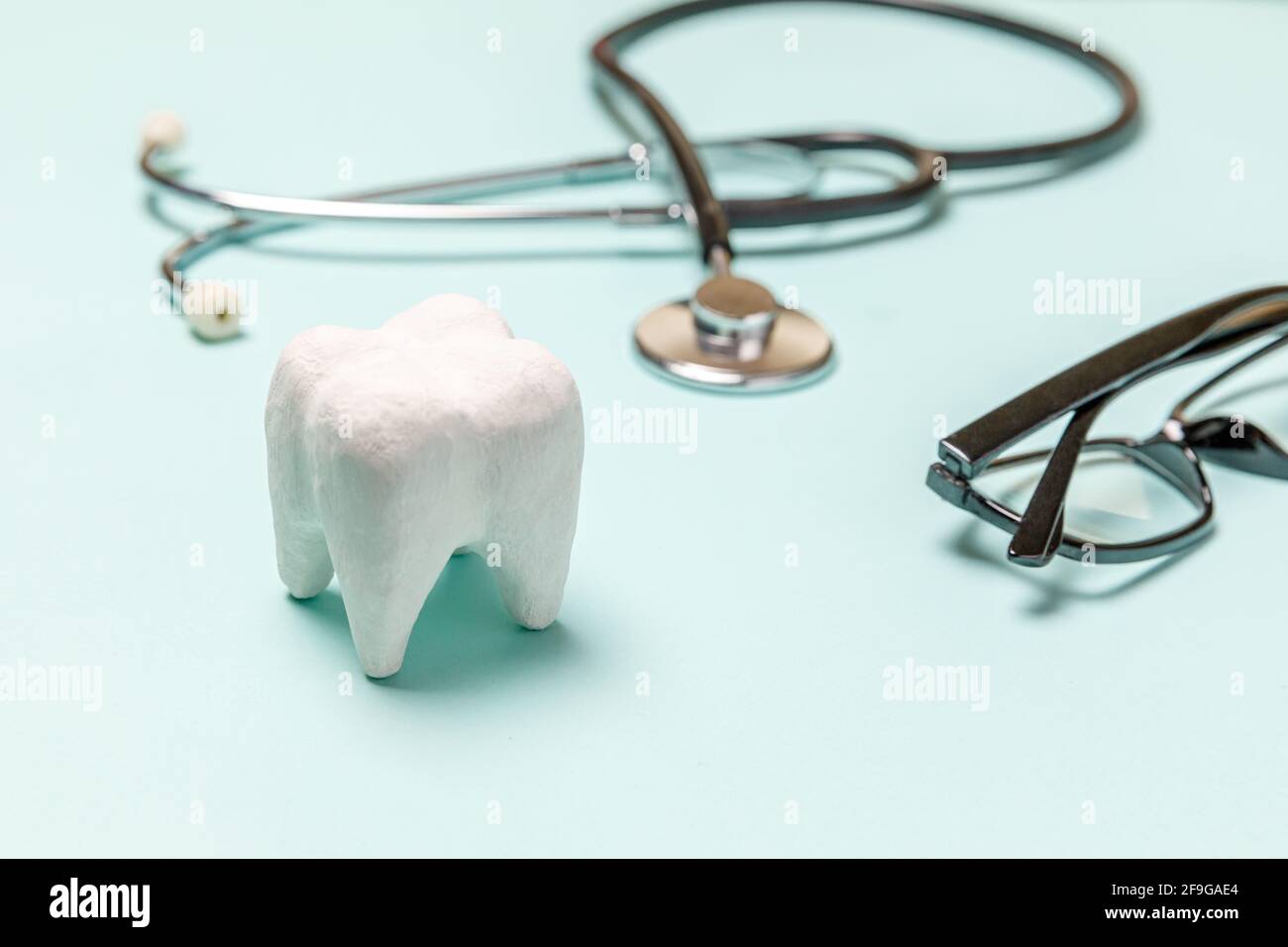 Gesundheit Zahnpflege Konzept. Medizingeräte Stethoskop weiß gesunde Zahngläser auf pastellblauem Hintergrund isoliert. Gerät für denti Stockfoto
