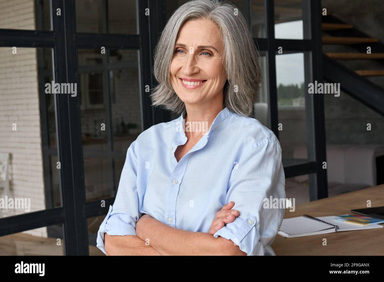 Porträt einer lächelnden Geschäftsfrau, die im Heimbüro steht. Stockfoto