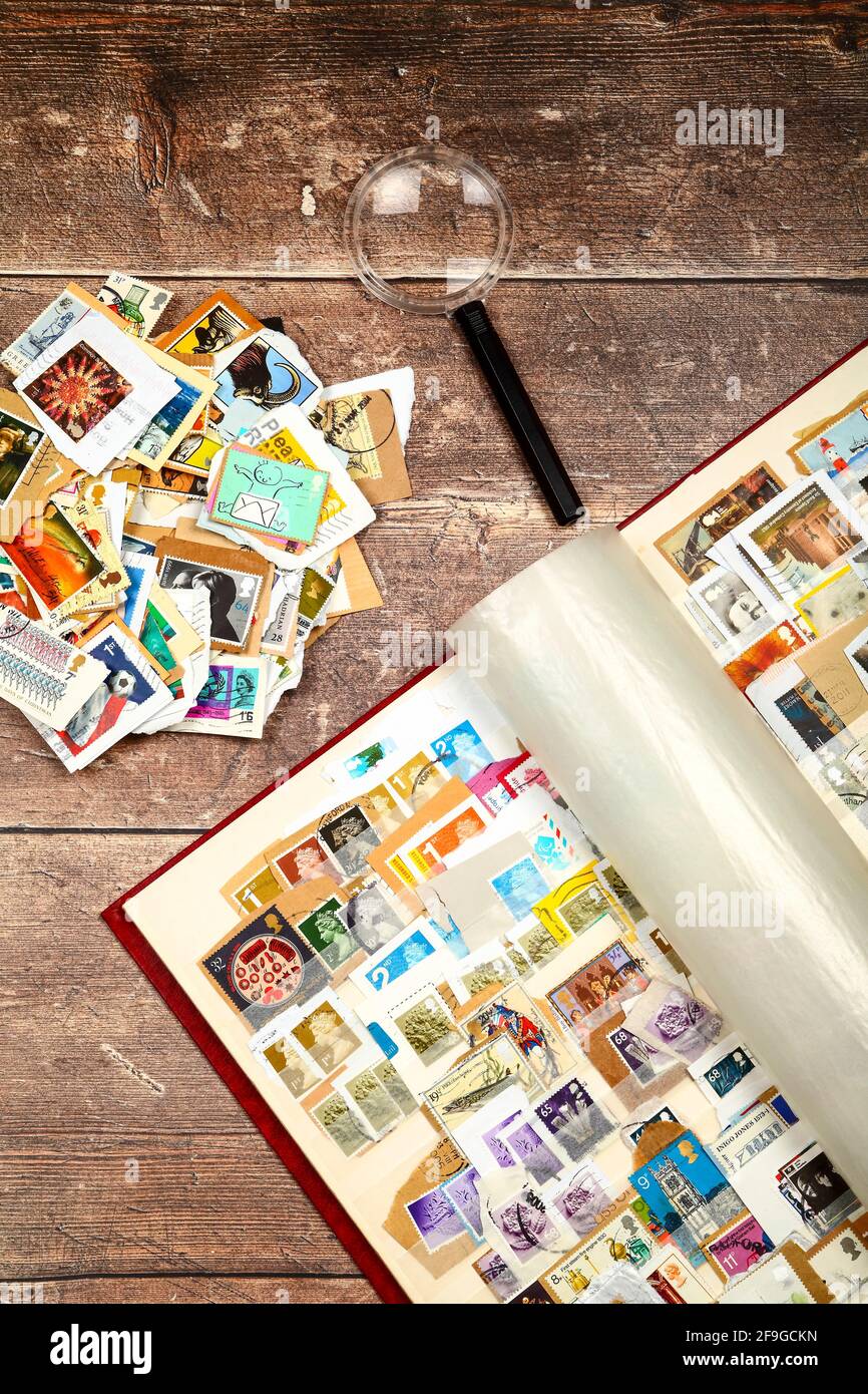 Briefmarkenalbum voll gebrauchter britischer Briefmarken Eine rustikale Holztischplatte Stockfoto