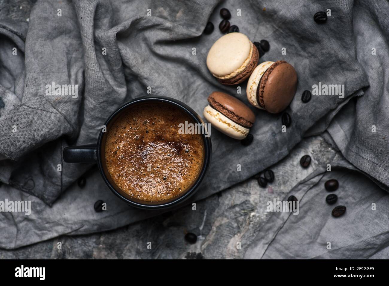 Macaron oder Makronen süße Plätzchen Desserts und eine Tasse Kaffee auf einem Holztisch, Tischansicht Stockfoto