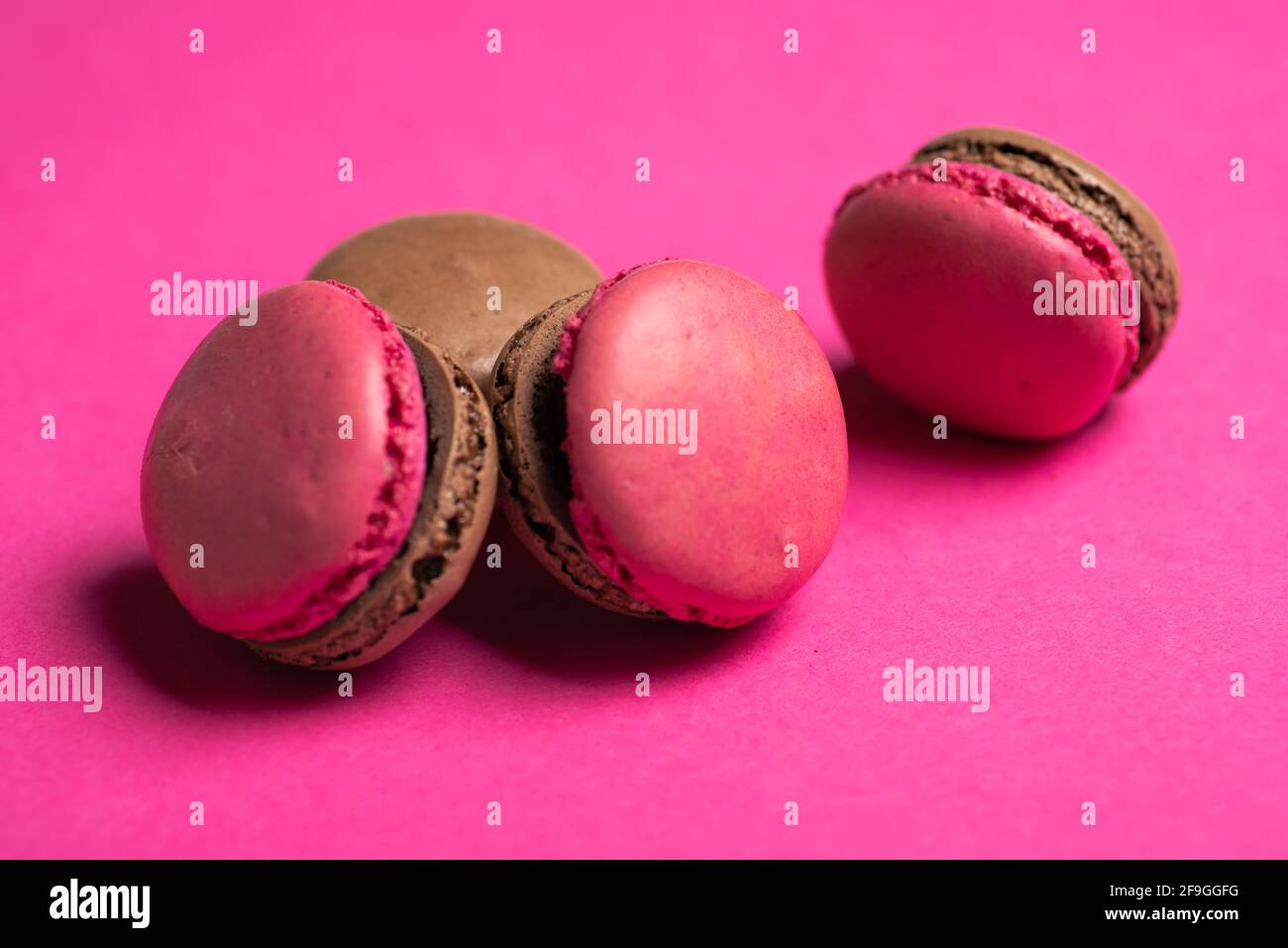 Pinkfarbener Macaron oder süßer Makronen-Plätzchendesserts auf rosa Hintergrund Stockfoto