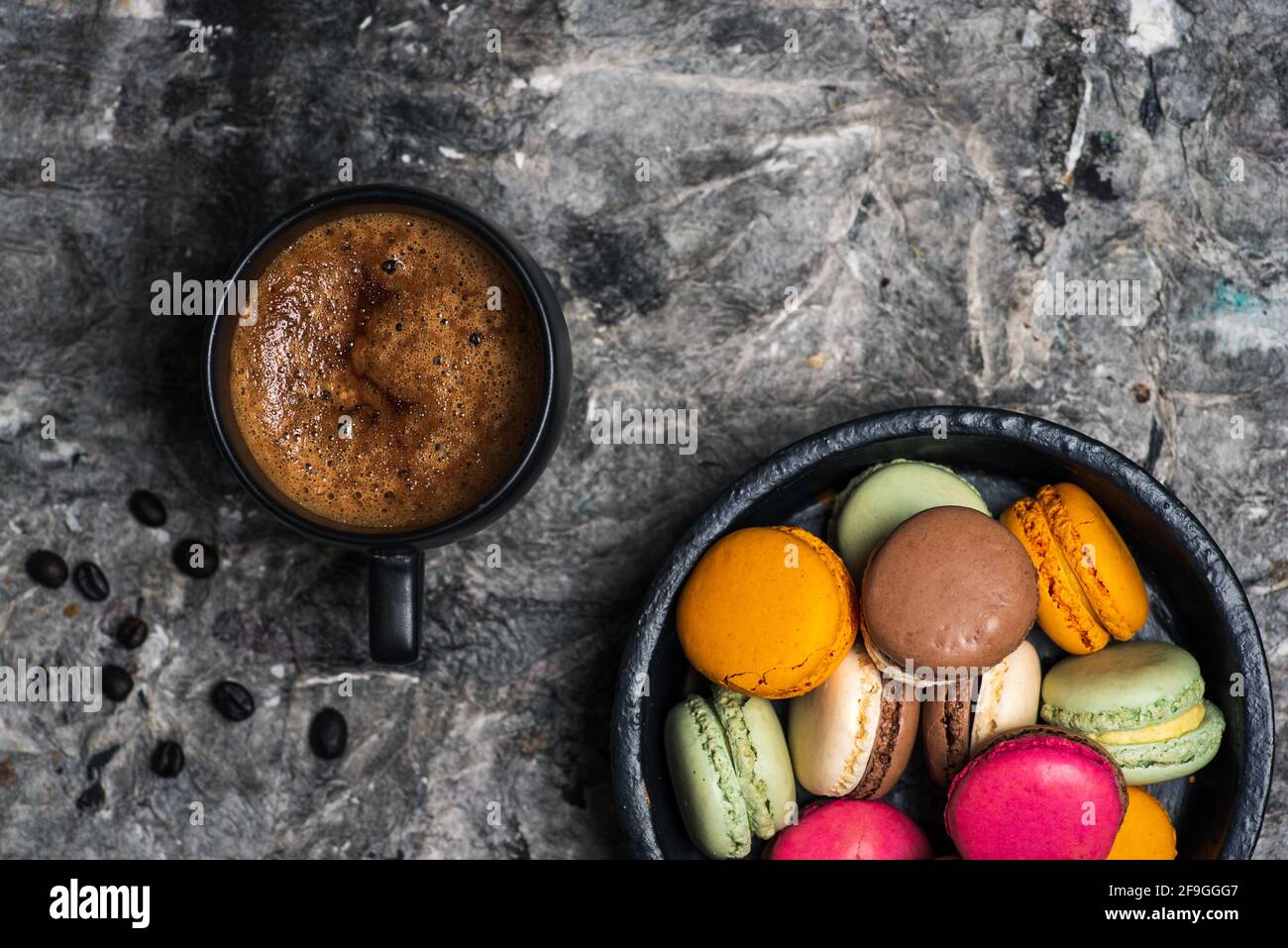 Macaron oder Makronen süße Plätzchen Desserts und eine Tasse Kaffee auf einem Holztisch, Tischansicht Stockfoto