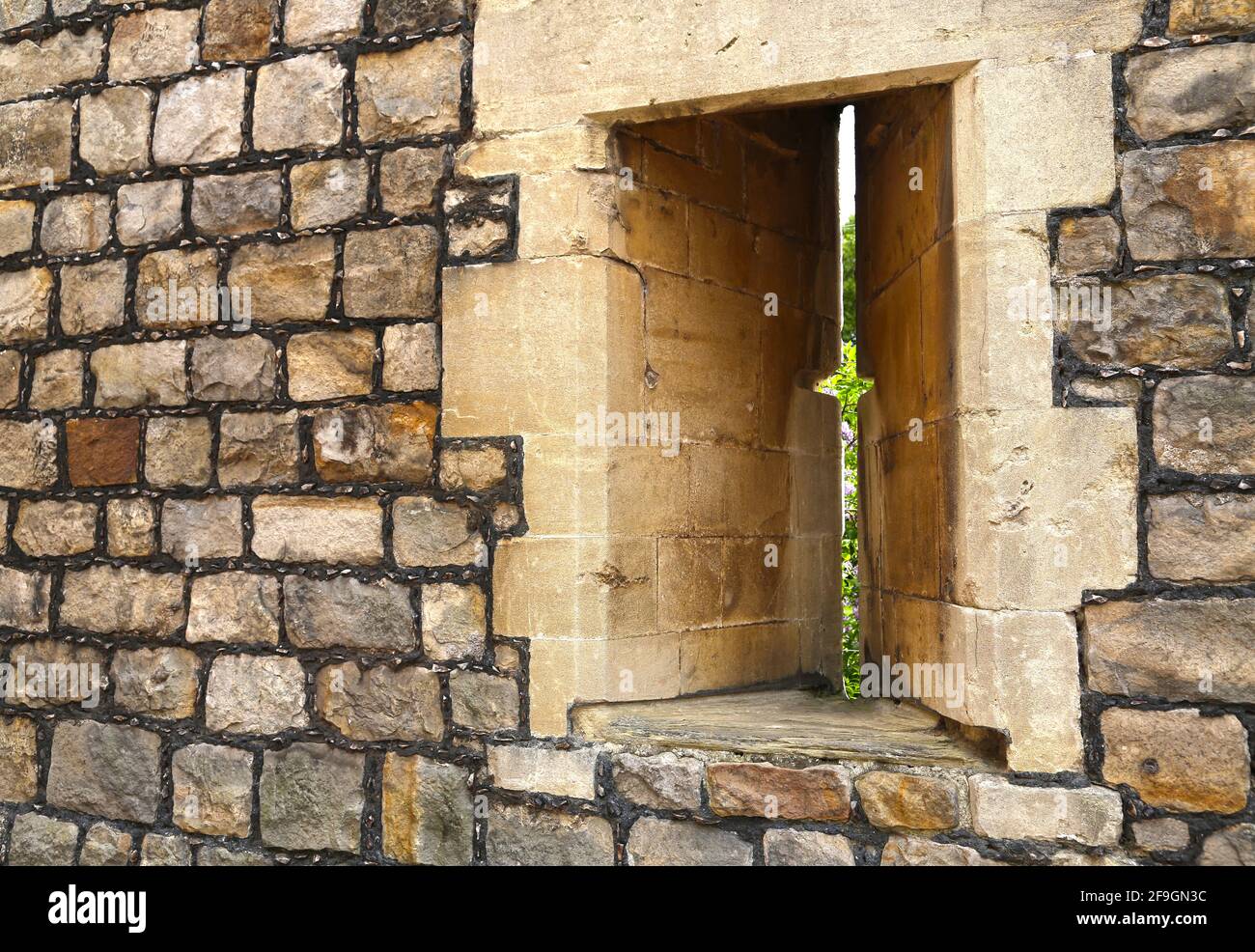 Vertikale Öffnung des Pfeilschlitzfensters in einer Befestigungsmauer am Schloss Windsor. Stockfoto