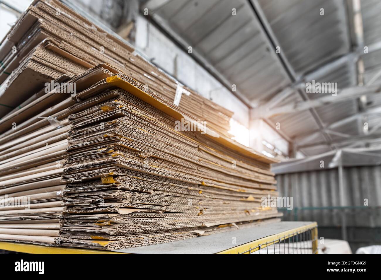 Stapeln Sie einen vorbereiteten Stapel aus gebrauchter komprimierter Wellpappe und Altpapierverpackung, der für das Recycling und die Wiederverwendung im Industriezentrum gesammelt wurde. Recycelbar Stockfoto