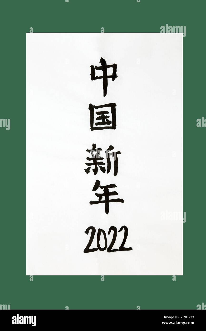 Chinesische Neujahrskalligrafie 2022 auf Reispapier und grünem Hintergrund. Übersetzung liest sich als chinesisches Neujahr 2022. Stockfoto