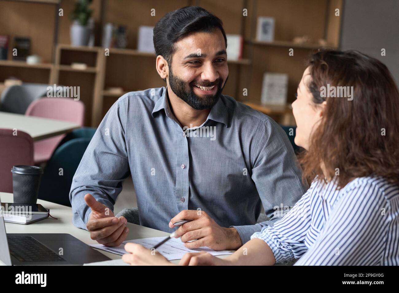 Multiethnisches Interview mit einem glücklichen, lächelnden HR-Manager und einem jungen Profi. Stockfoto