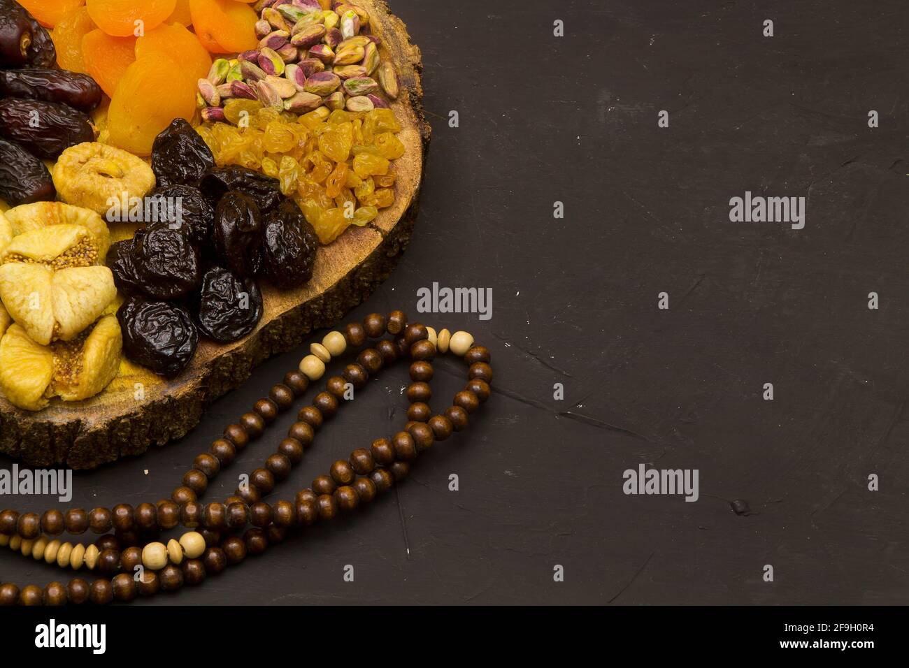 Ramadan Food Hintergrund mit Kopierraum - schwarzer Holztisch Mit verschiedenen arabischen Speisen ( getrocknete Datteln und Nüsse) bereit für Iftar Stockfoto