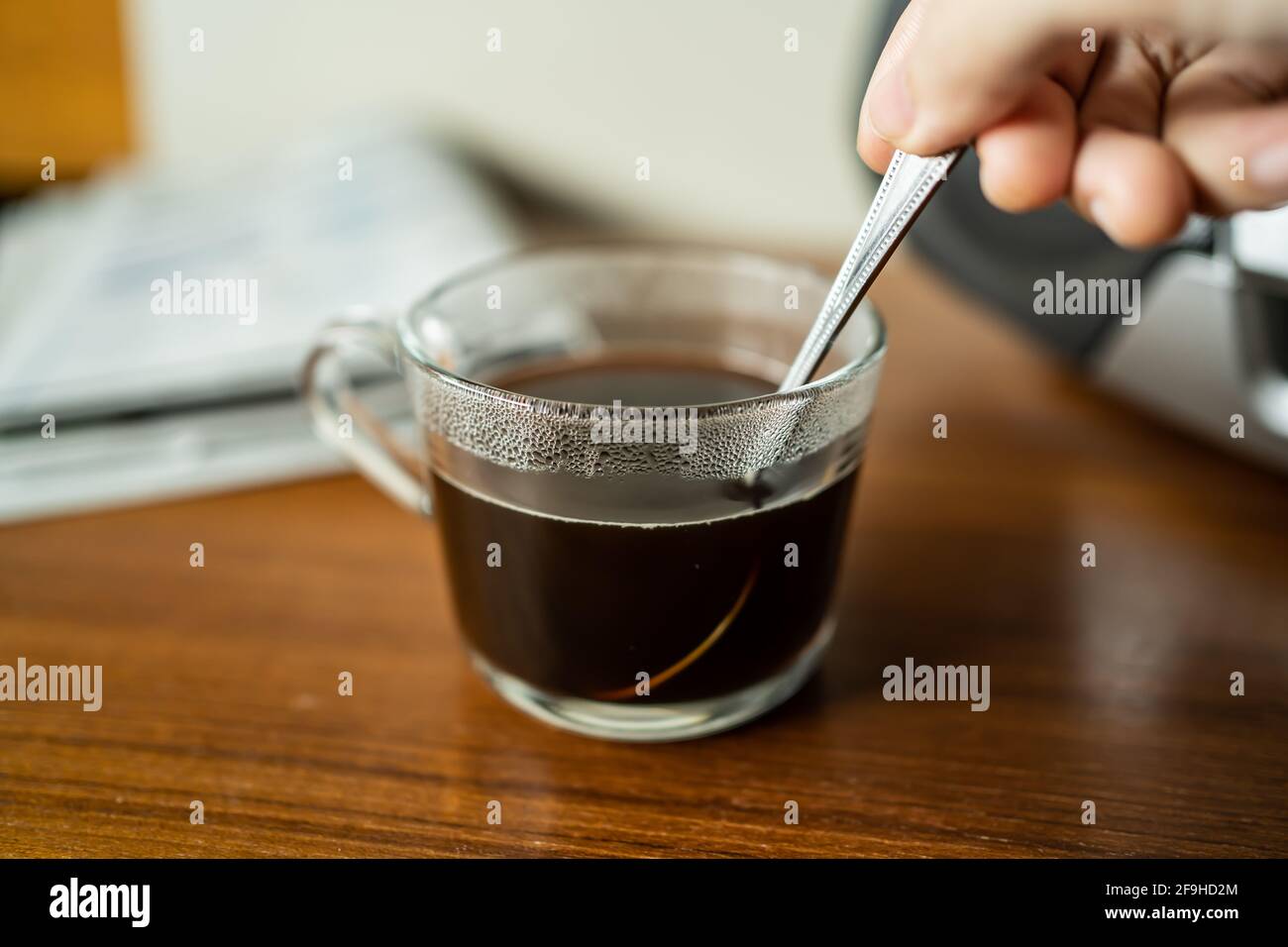 Rühren Sie den Kaffee in einer Tasse mit Teelöffel Stockfoto