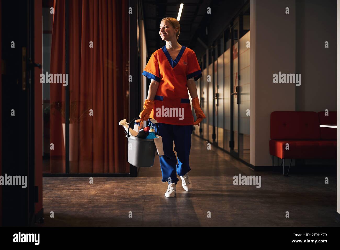 Es war eine erfreulicher junger Putzer, der den Bürogang entlang ging Stockfoto