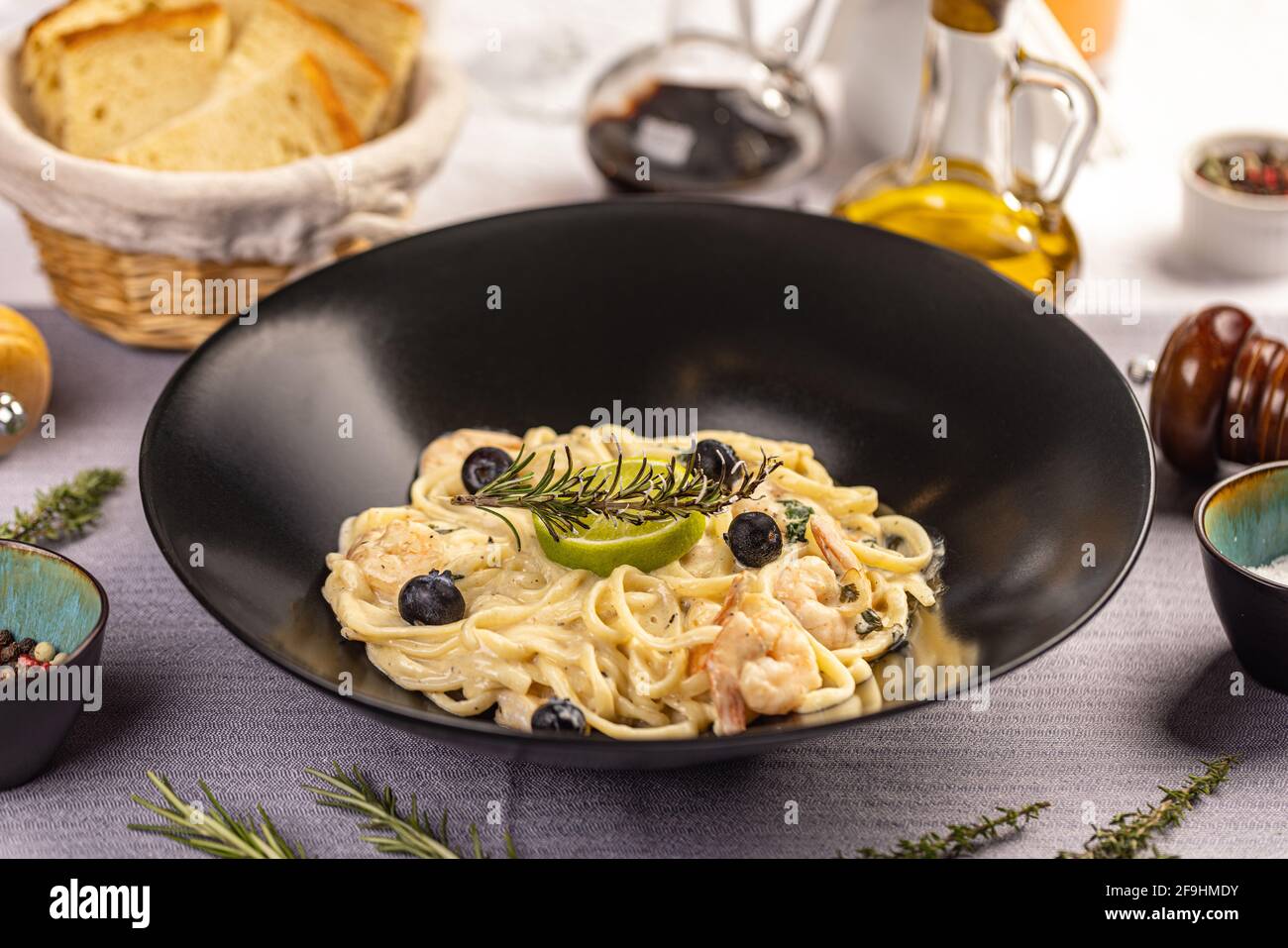 Pasta Linguine mit Käse und flammenden Garnelen auf dem Restauranttisch Stockfoto
