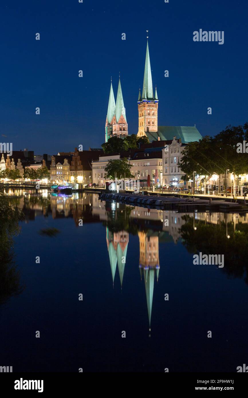 Die Kirchen St. Petri und St. Mary ragen über historischen Häusern am Rande der Trave in Lübeck (Lübeck), Schleswig-Holstein, Deutschland Stockfoto