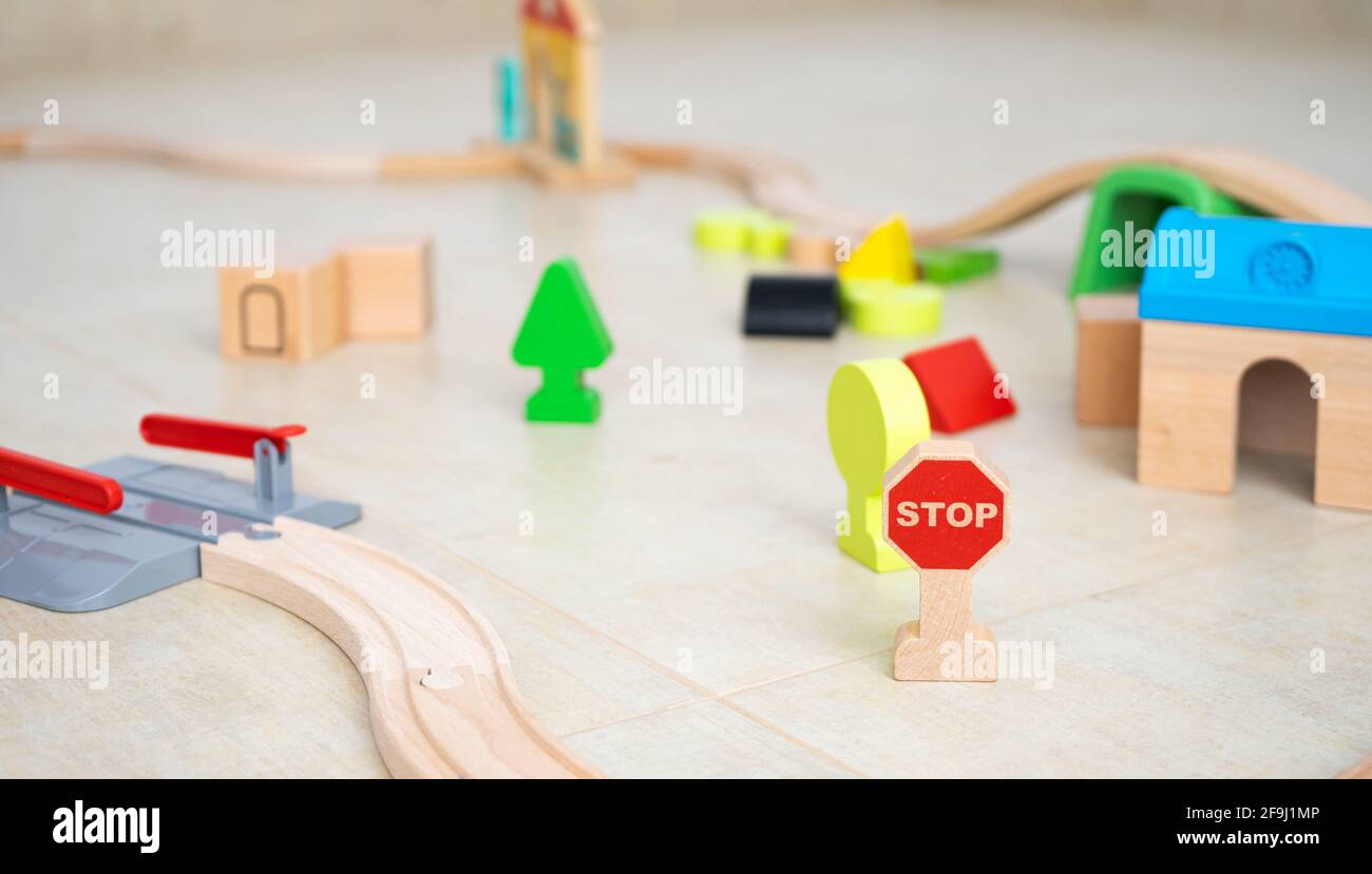 Hölzerne Spielzeugeisenbahn-Schienen auf einem Zimmerboden Stockfoto